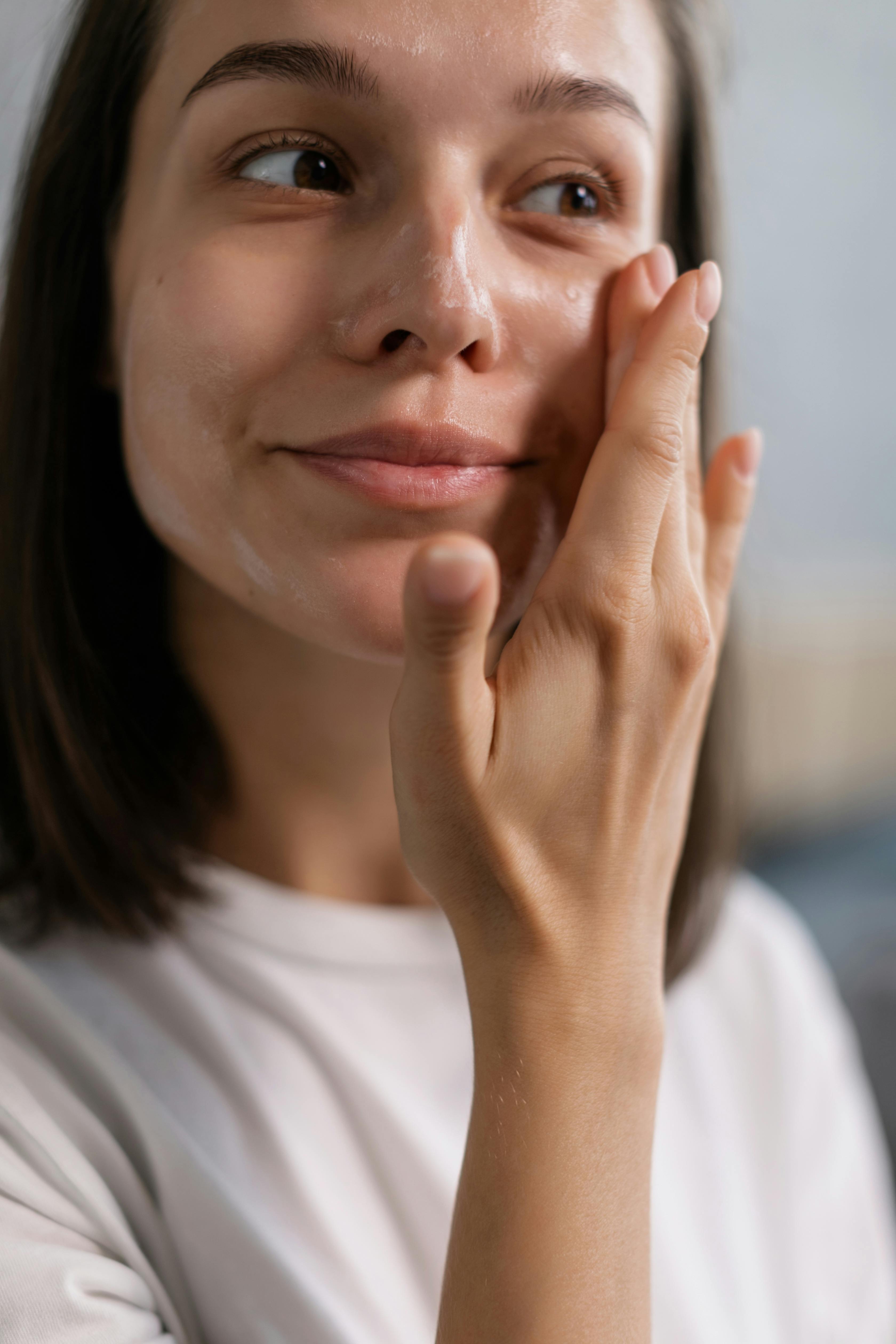 Woman moisturizing her face | Source: Pexels