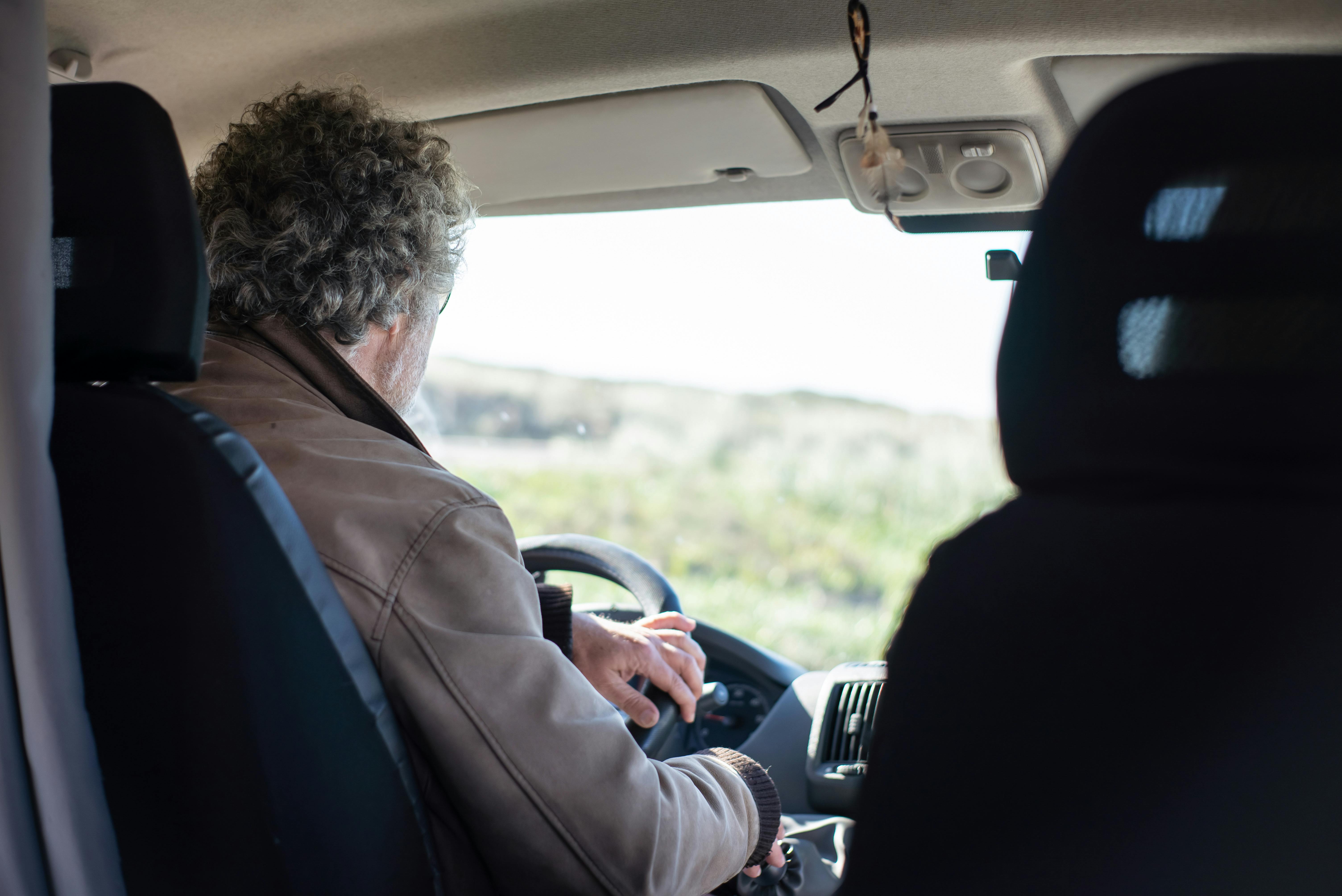 Man driving alone on a rural road | Source: Pexels
