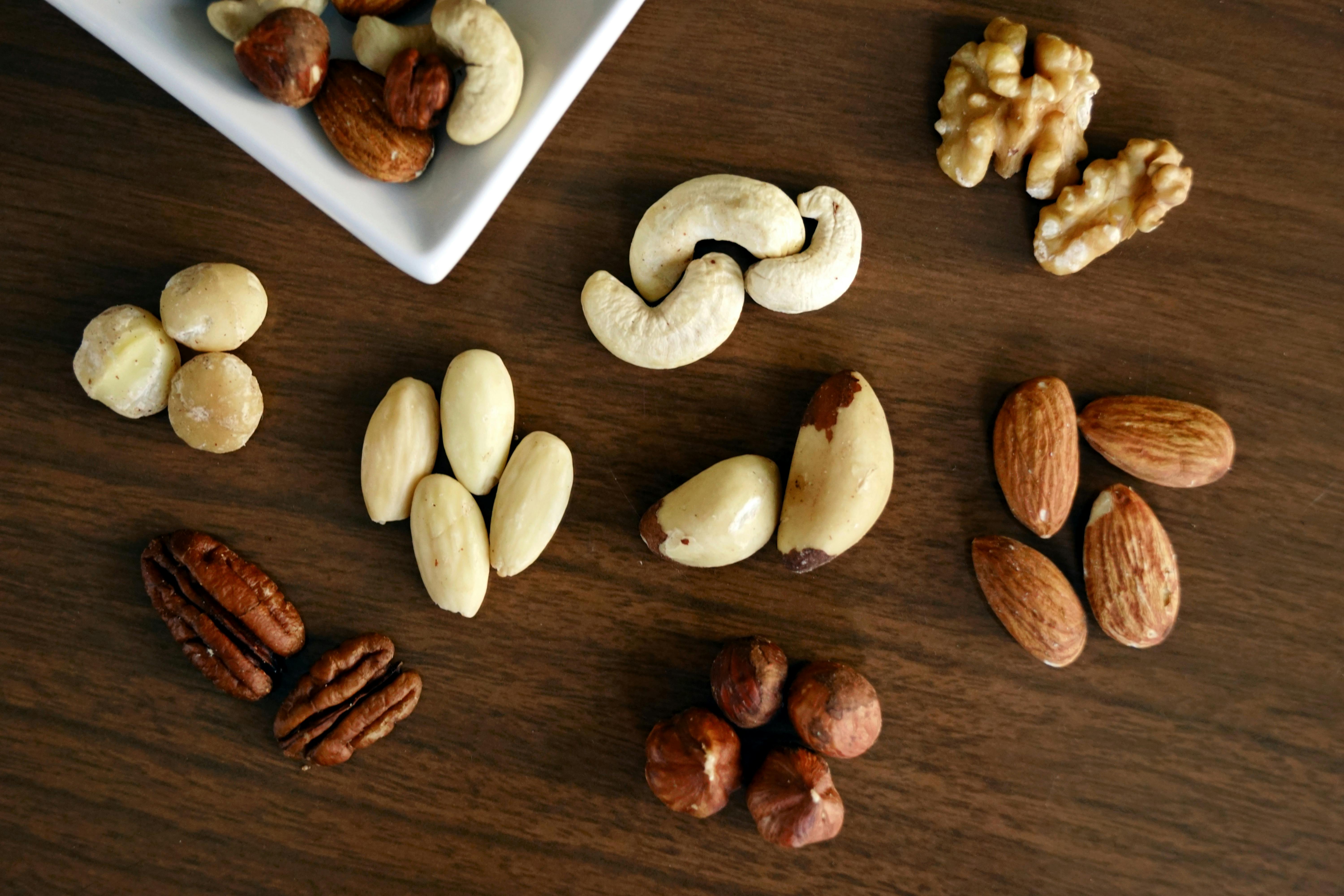 Variety of brown nuts on brown wood panel high angle photo | Source: Pexels