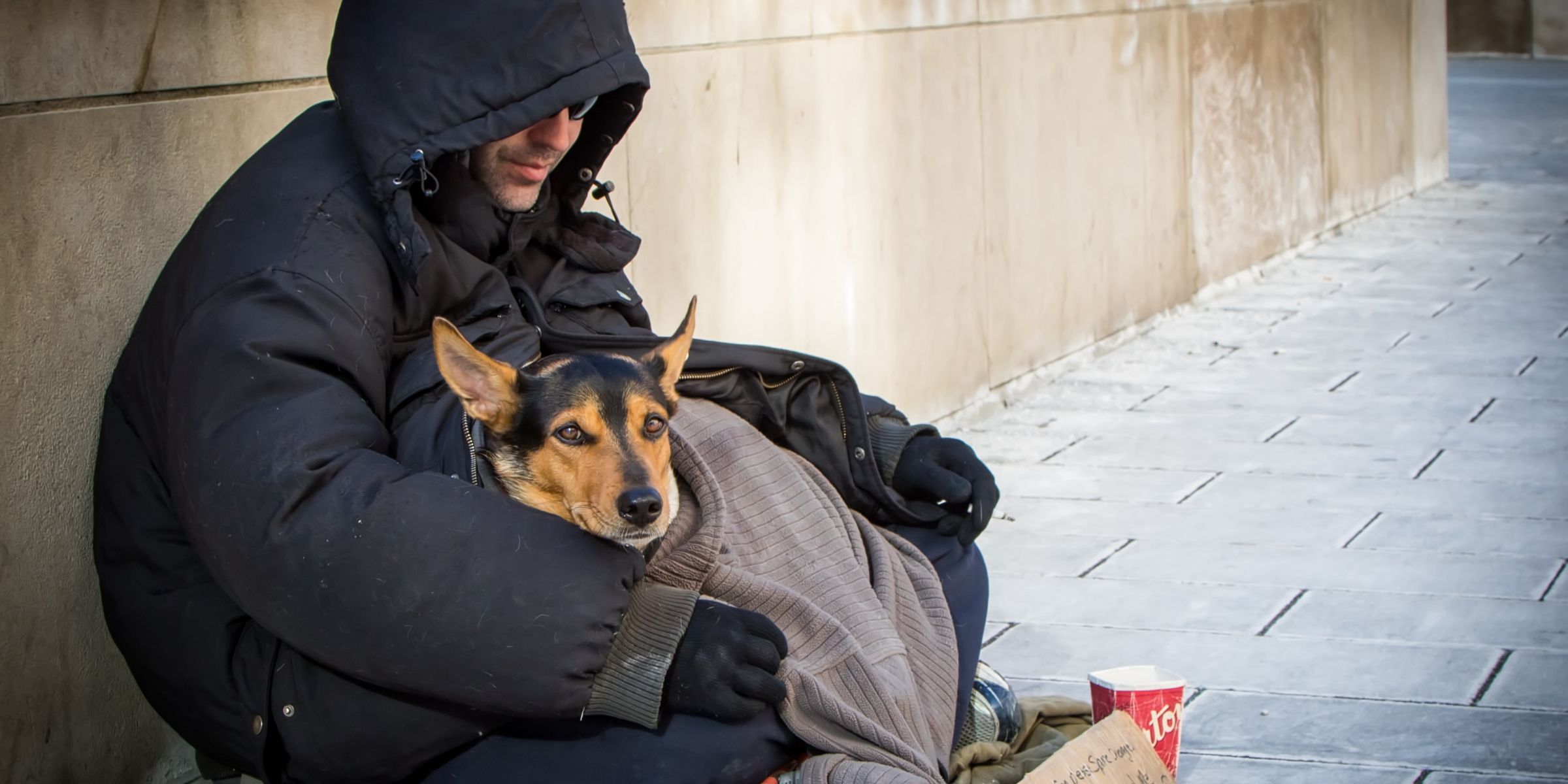 A homeless man holding his dog | Source: Shutterstock