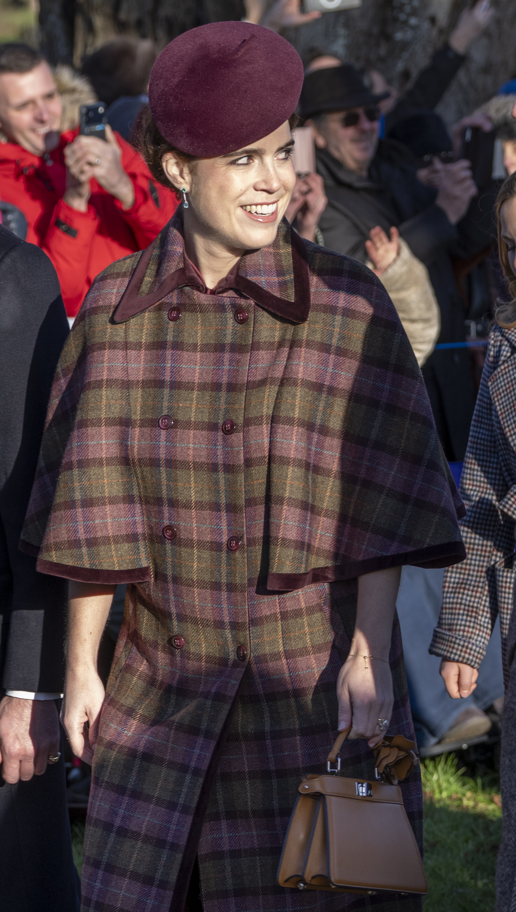 Princess Eugenie is seen among well-wishers at the Christmas Morning Service at St Mary Magdalene Church in Sandringham, Norfolk, in a plaid coat and burgundy hat.