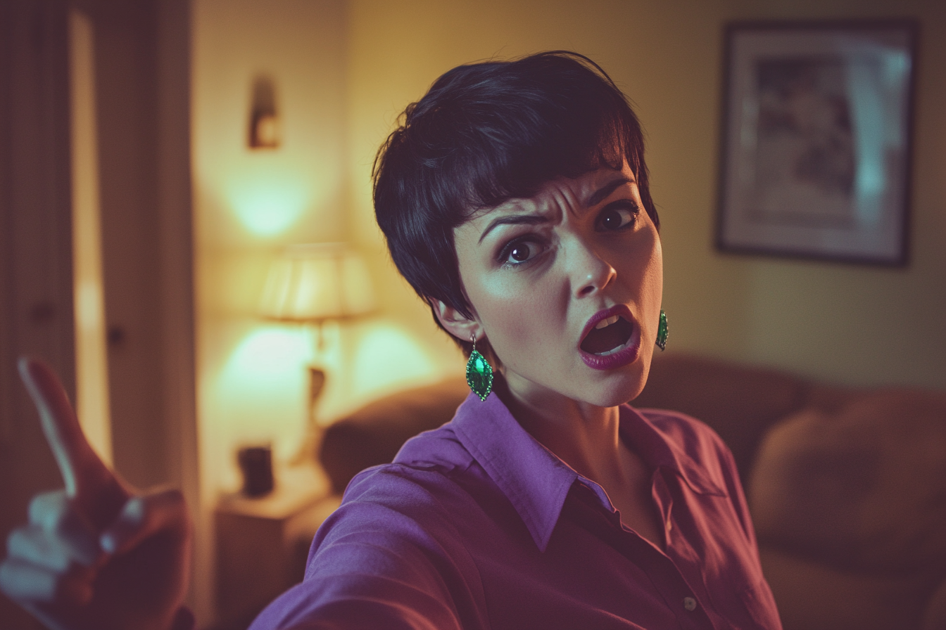 An angry woman in her 20s stands in the living room pointing her finger | Source: No source