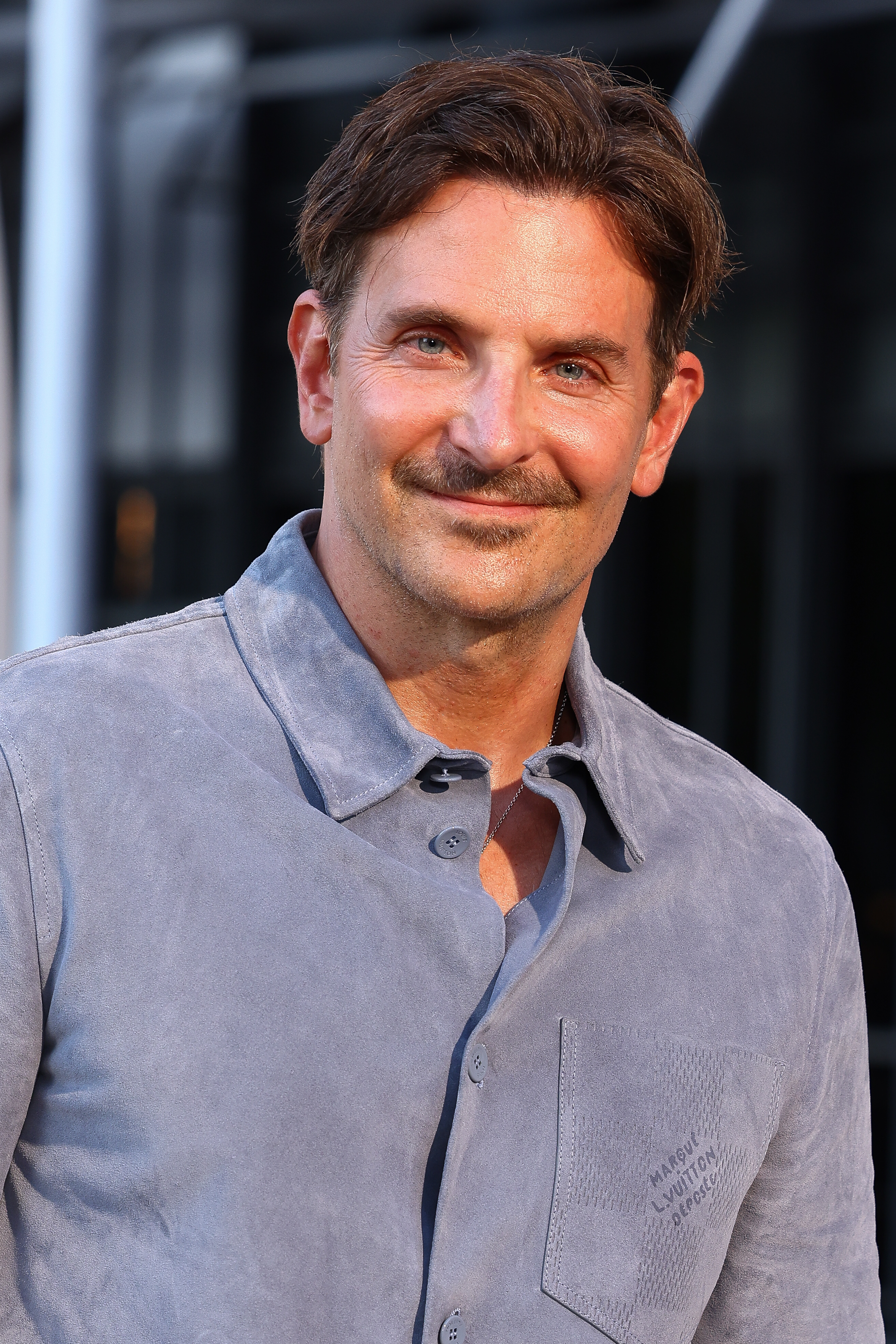 Cooper was seen with a thin, dark mustache above his subtle smile and only a minimal trace of stubble elsewhere on his chin. Although his crow's feet are prominent, his skin looks bright and healthy, as he attended the Louis Vuitton Menswear Spring/Summer 2026 show as part of Paris Fashion Week on June 24, 2025, in Paris, France.