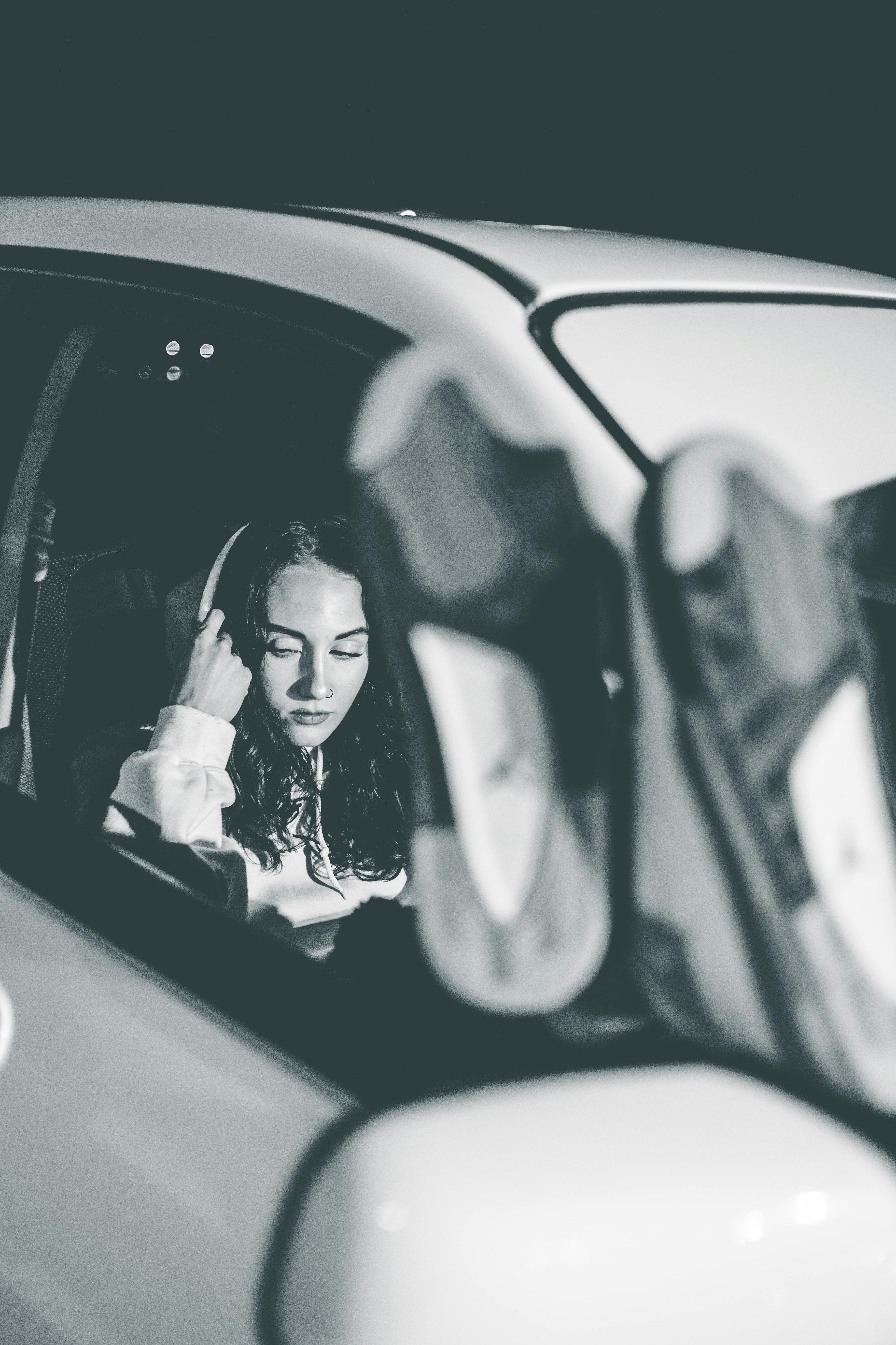 A serious woman sitting in the passenger seat of a car | Source: Pexels