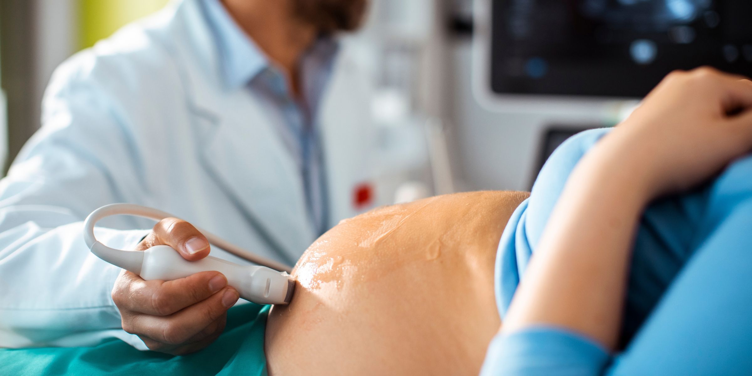 A doctor performing an ultrasound examination on a pregnant woman | Source: Shutterstock
