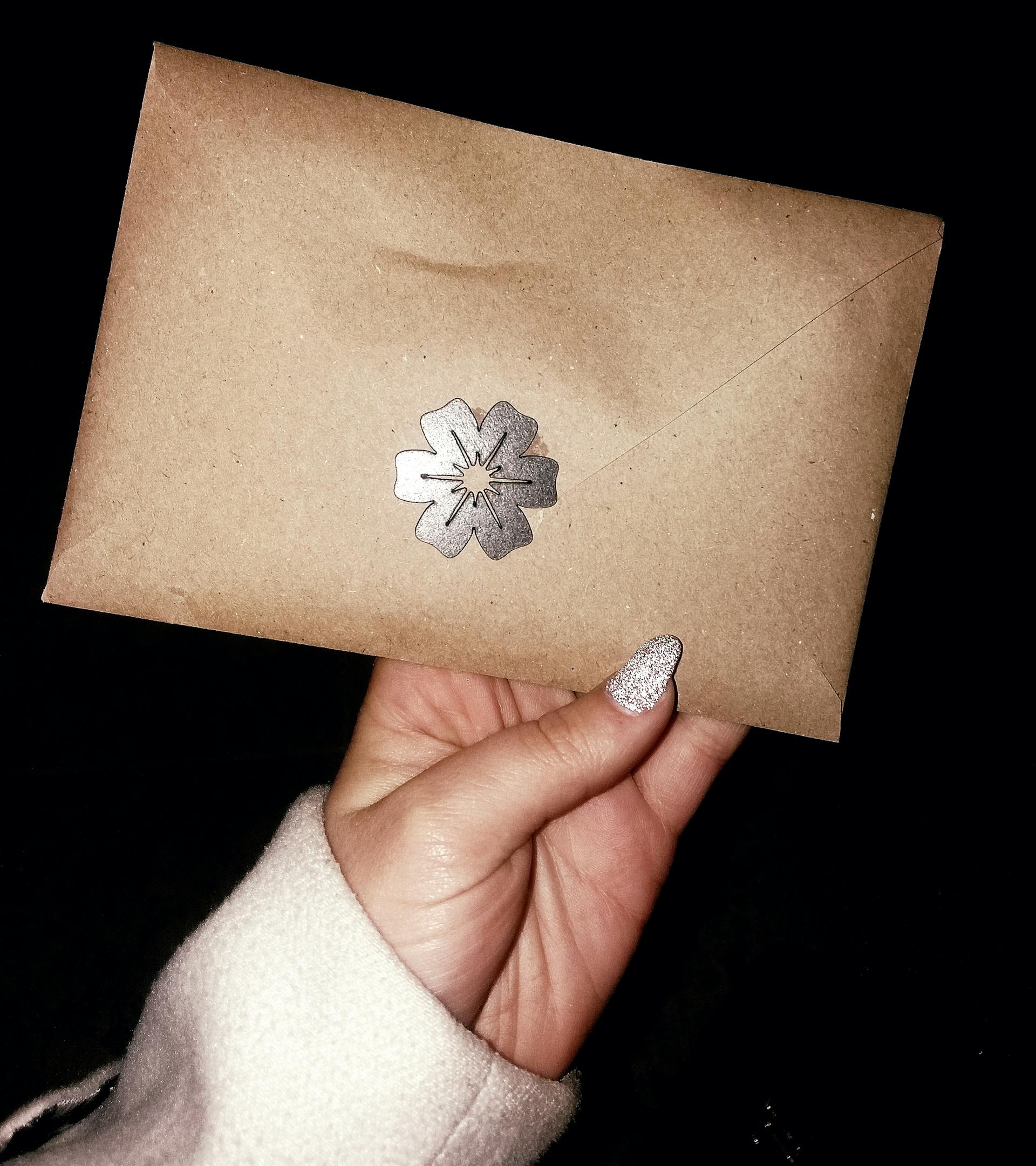 A woman holding out an envelope | Source: Pexels