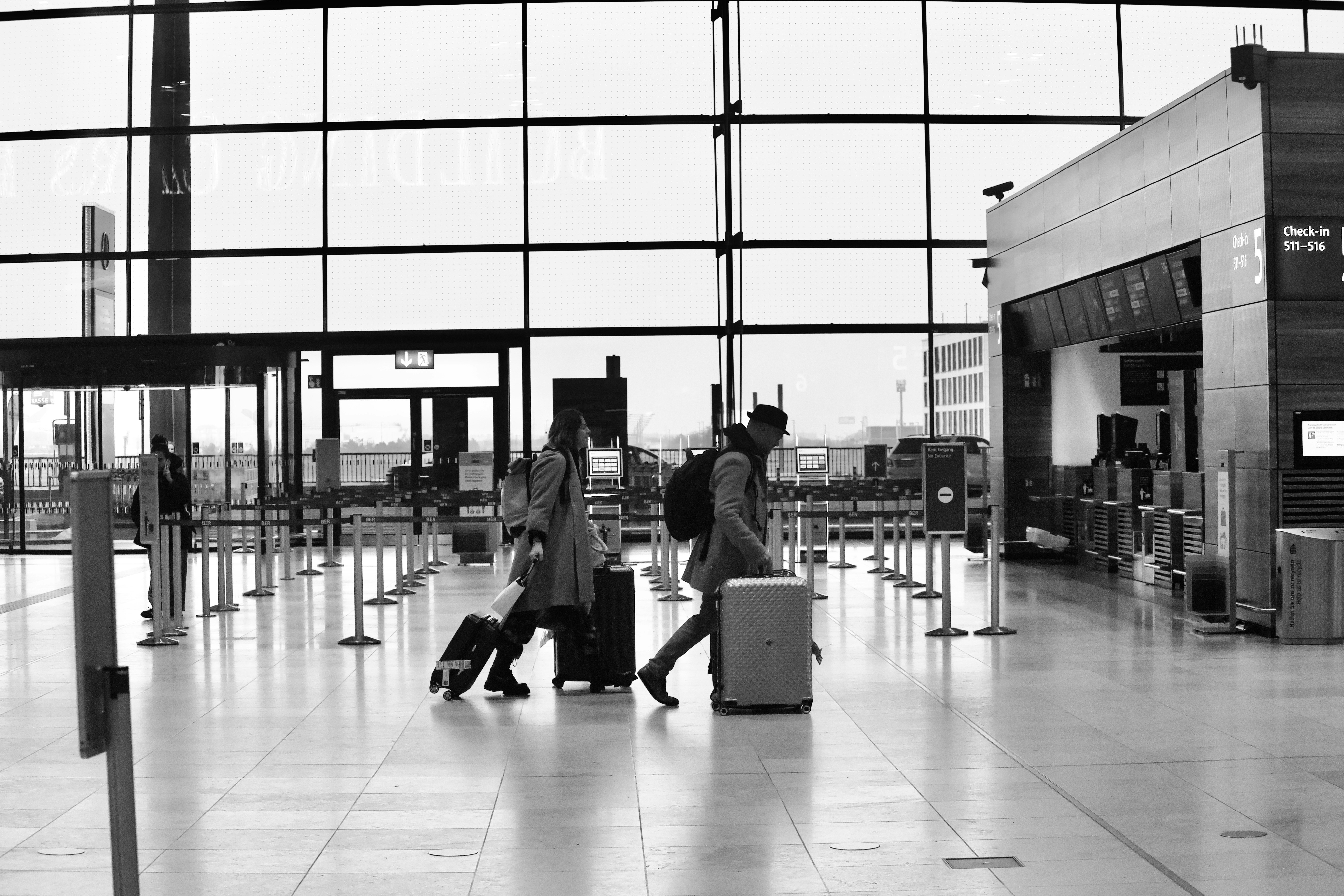 A couple pulling their luggage through an airport terminal | Source: Unsplash