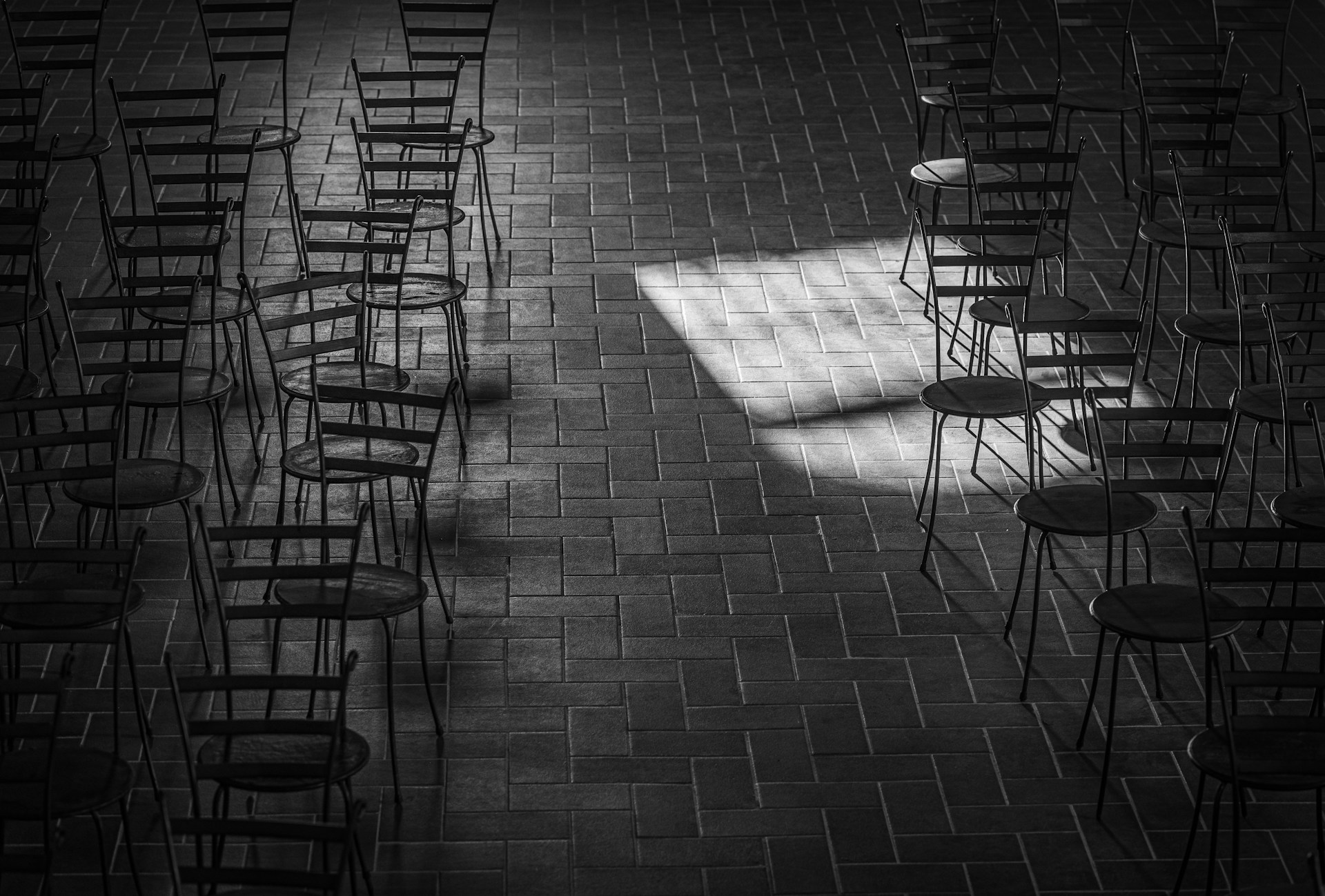 Grayscale shot of chairs in an empty room | Source: Unsplash