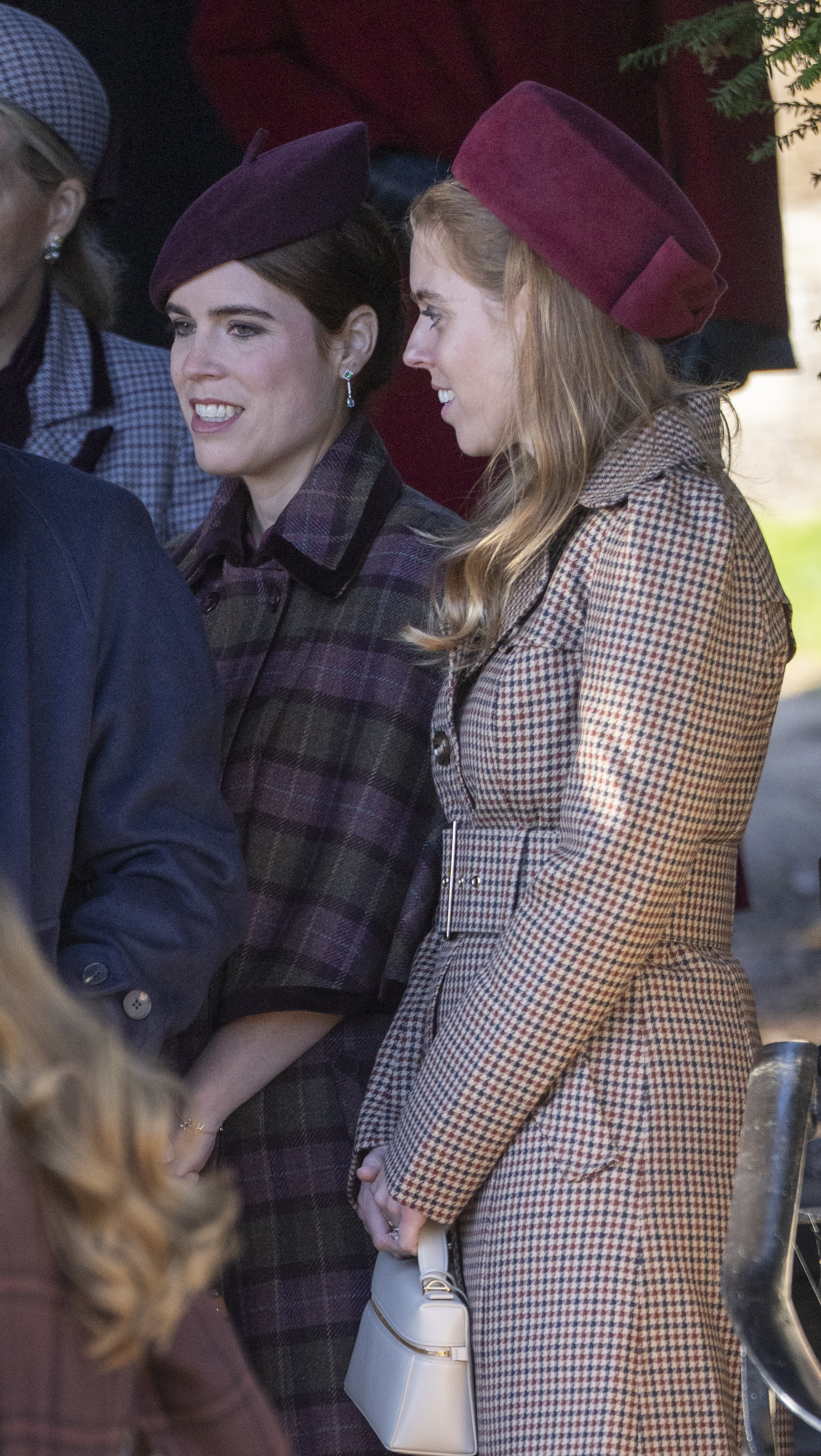 Princess Beatrice, Counsellor of State, and Princess Eugenie attend the Christmas Morning Service at St Mary Magdalene Church on December 25, 2025, in Sandringham, Norfolk, dressed in coordinated winter coats and burgundy hats.
