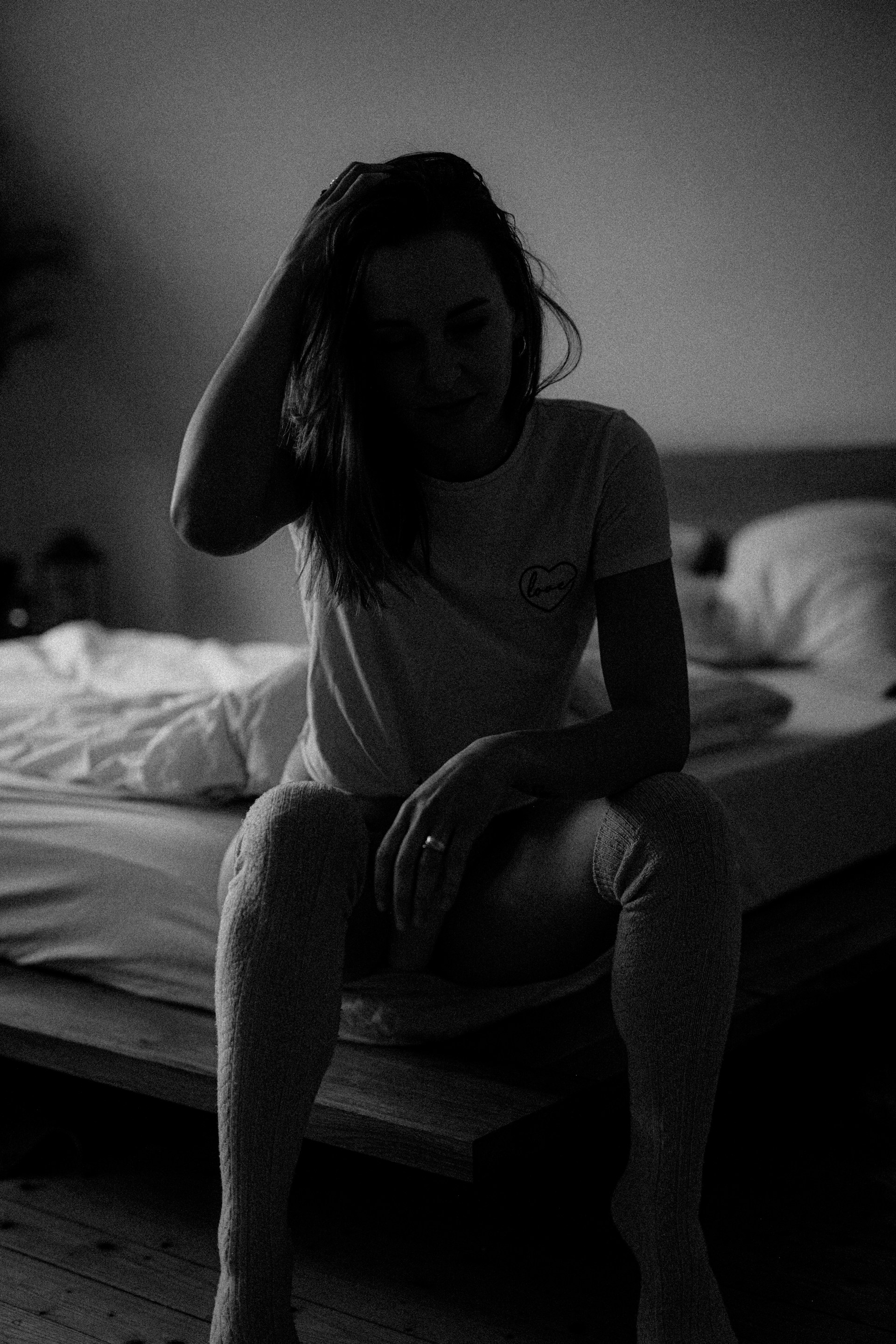 A woman sitting on the edge of a bed | Source: Unsplash