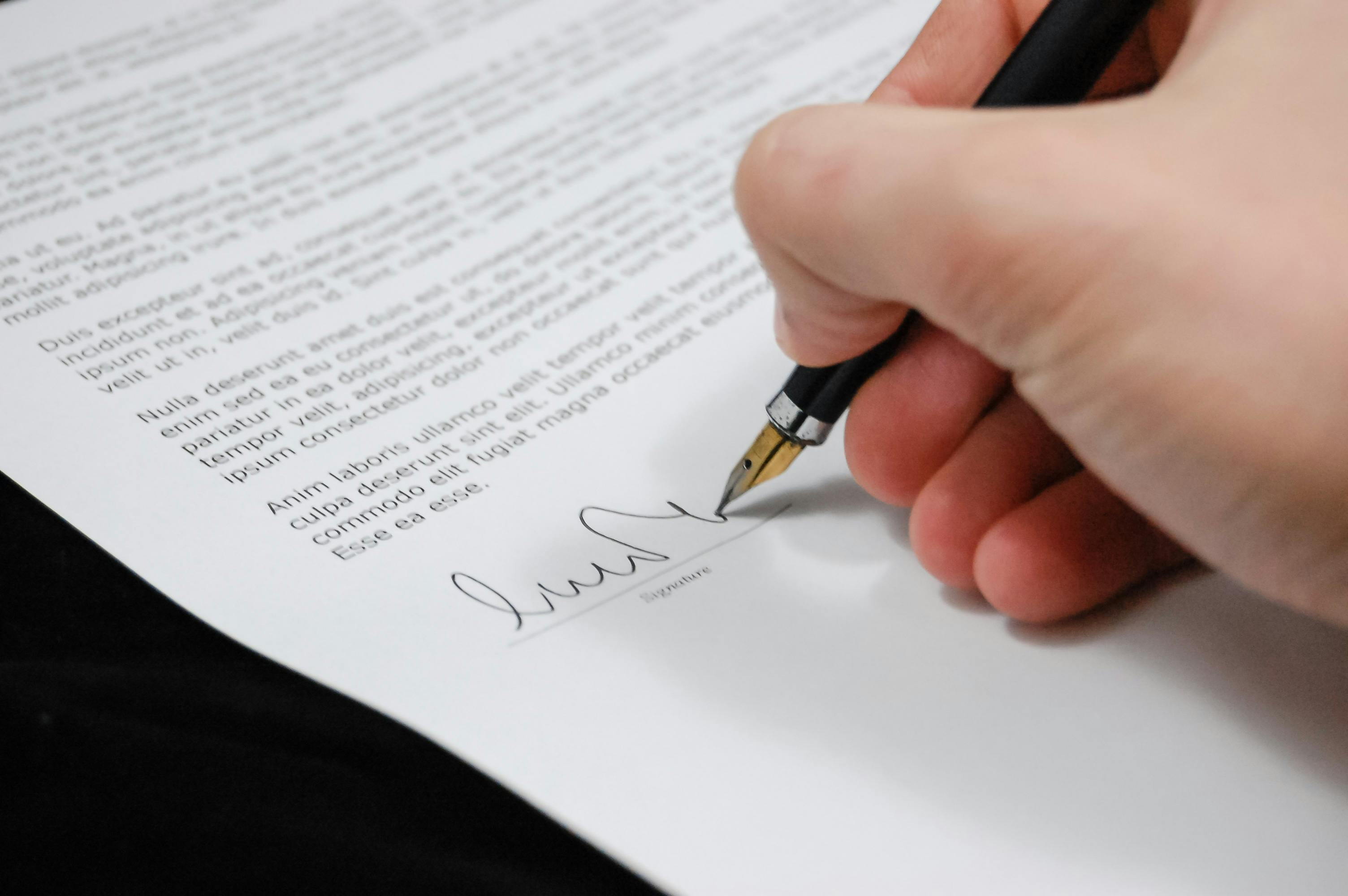 Person signing a document with a fountain pen | Source: Pexels