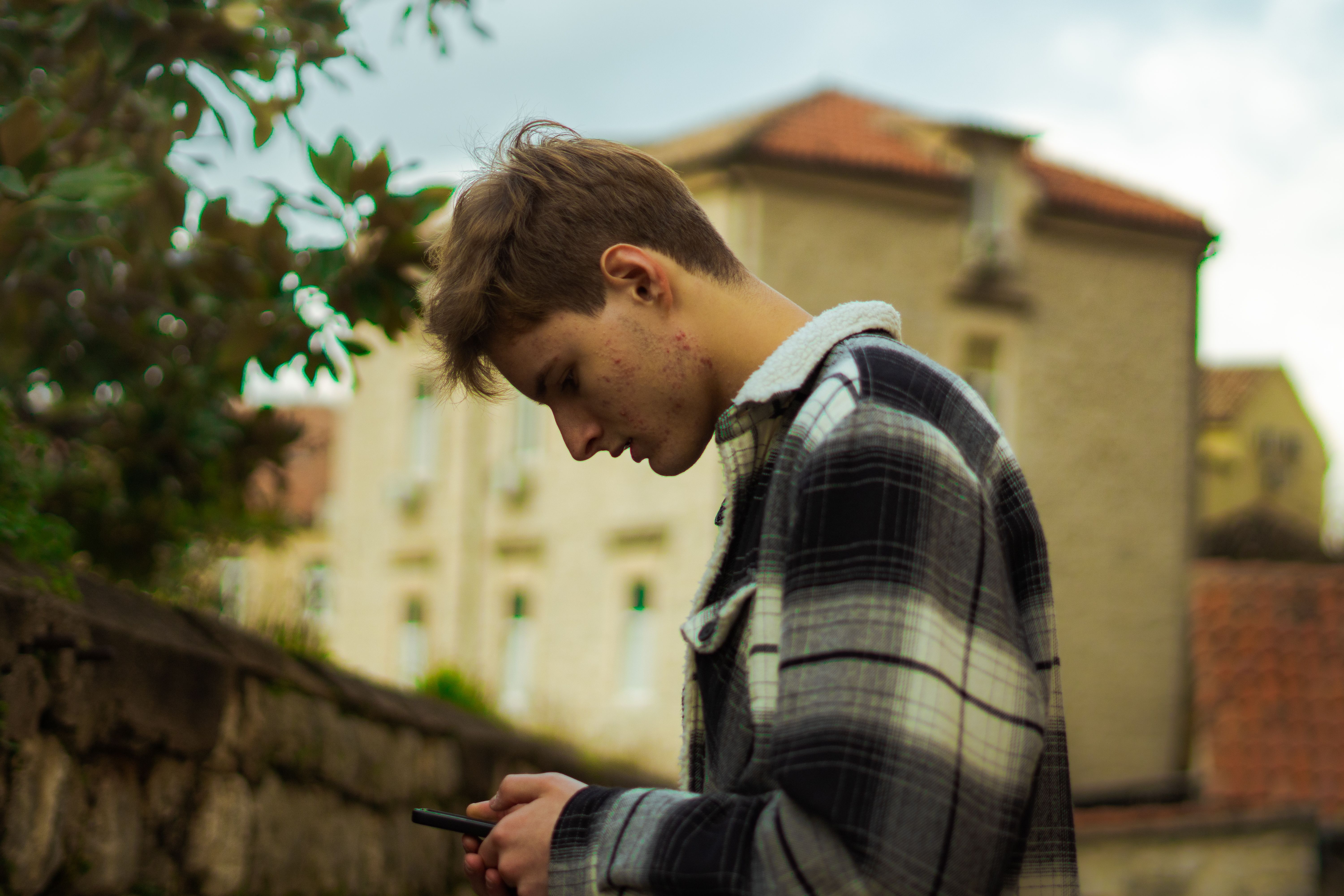 Profile of a teenager using a smartphone outdoors | Source: Pexels