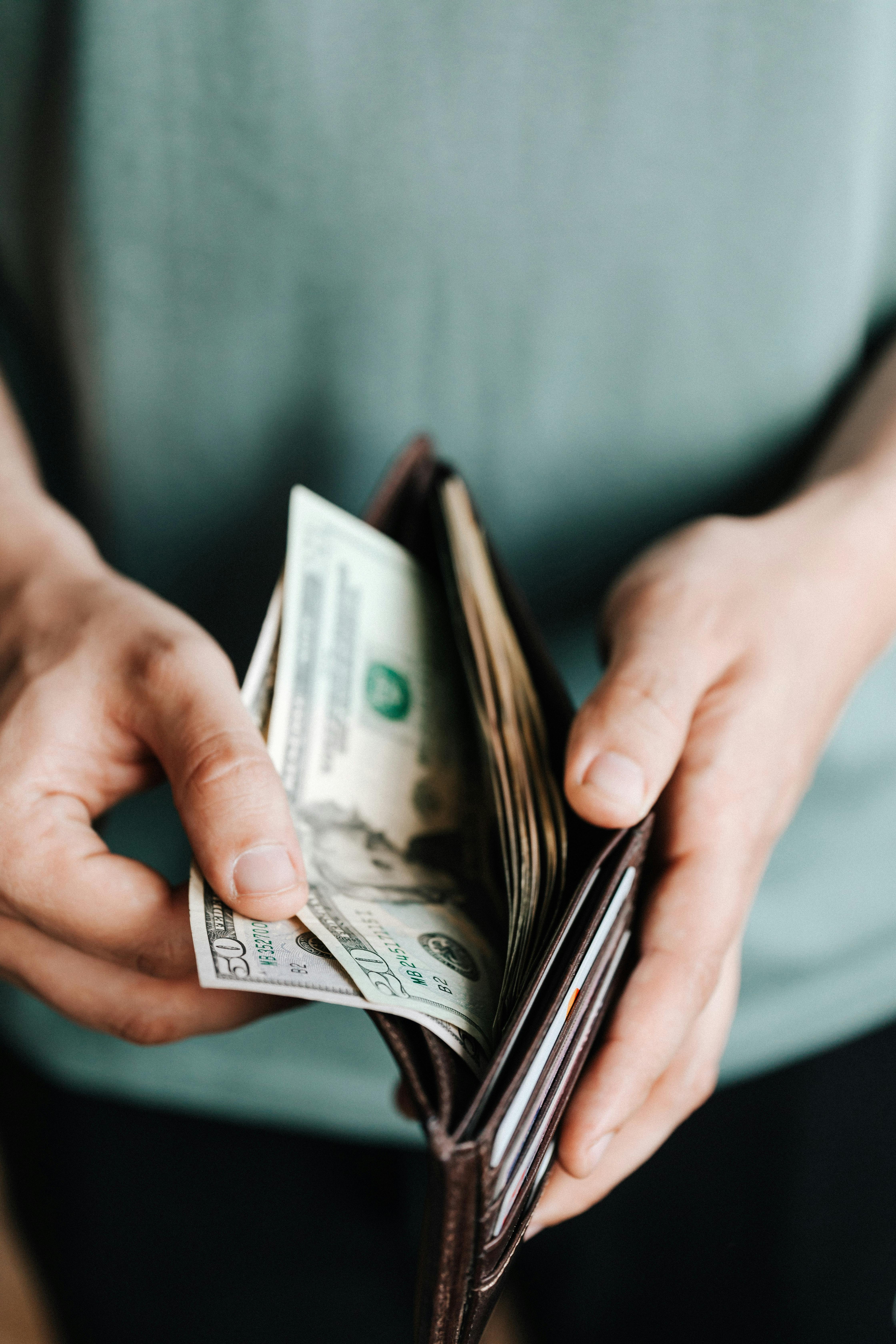 A man holding open his wallet | Source: Pexels