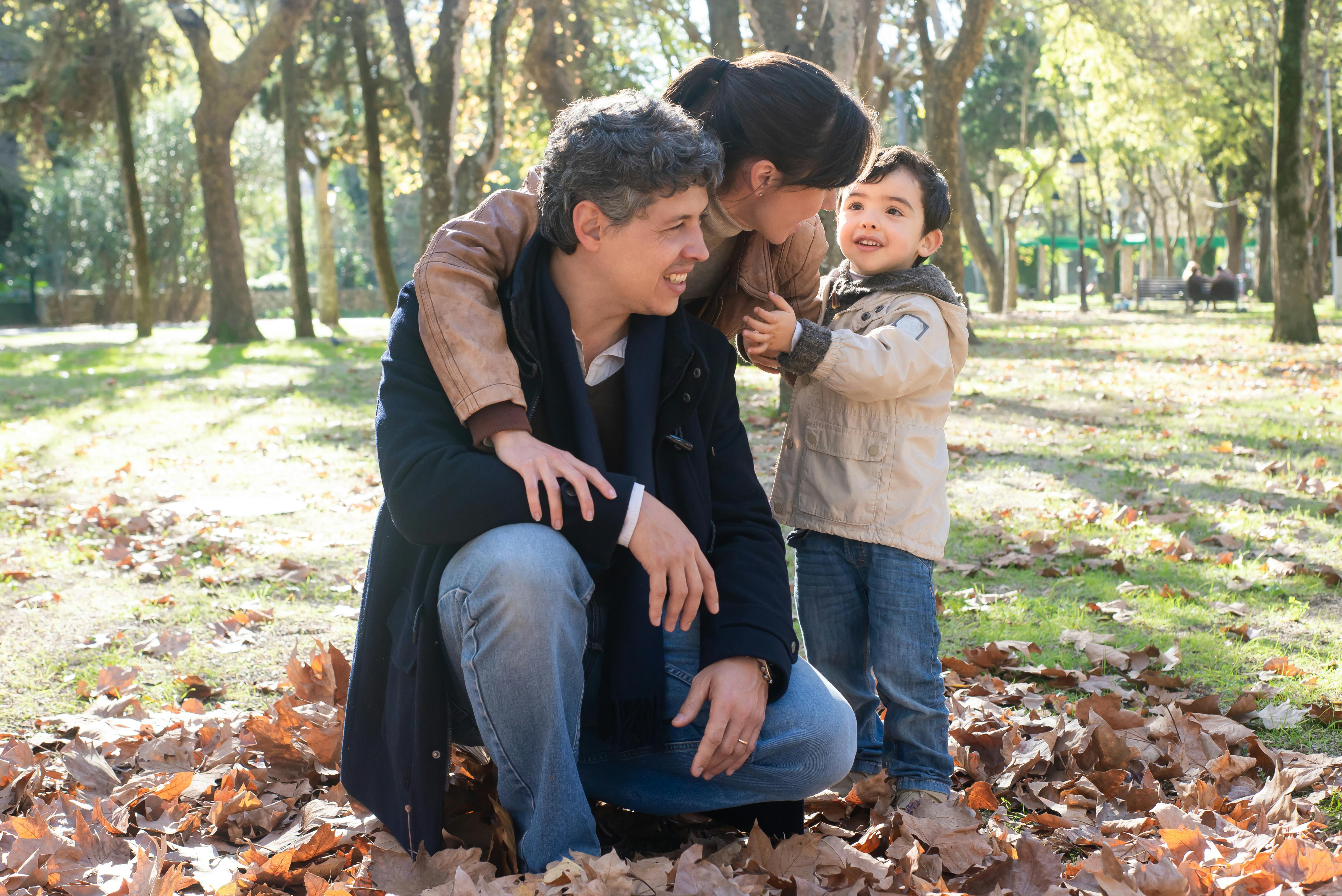 Parents and son outdoors fall leaves