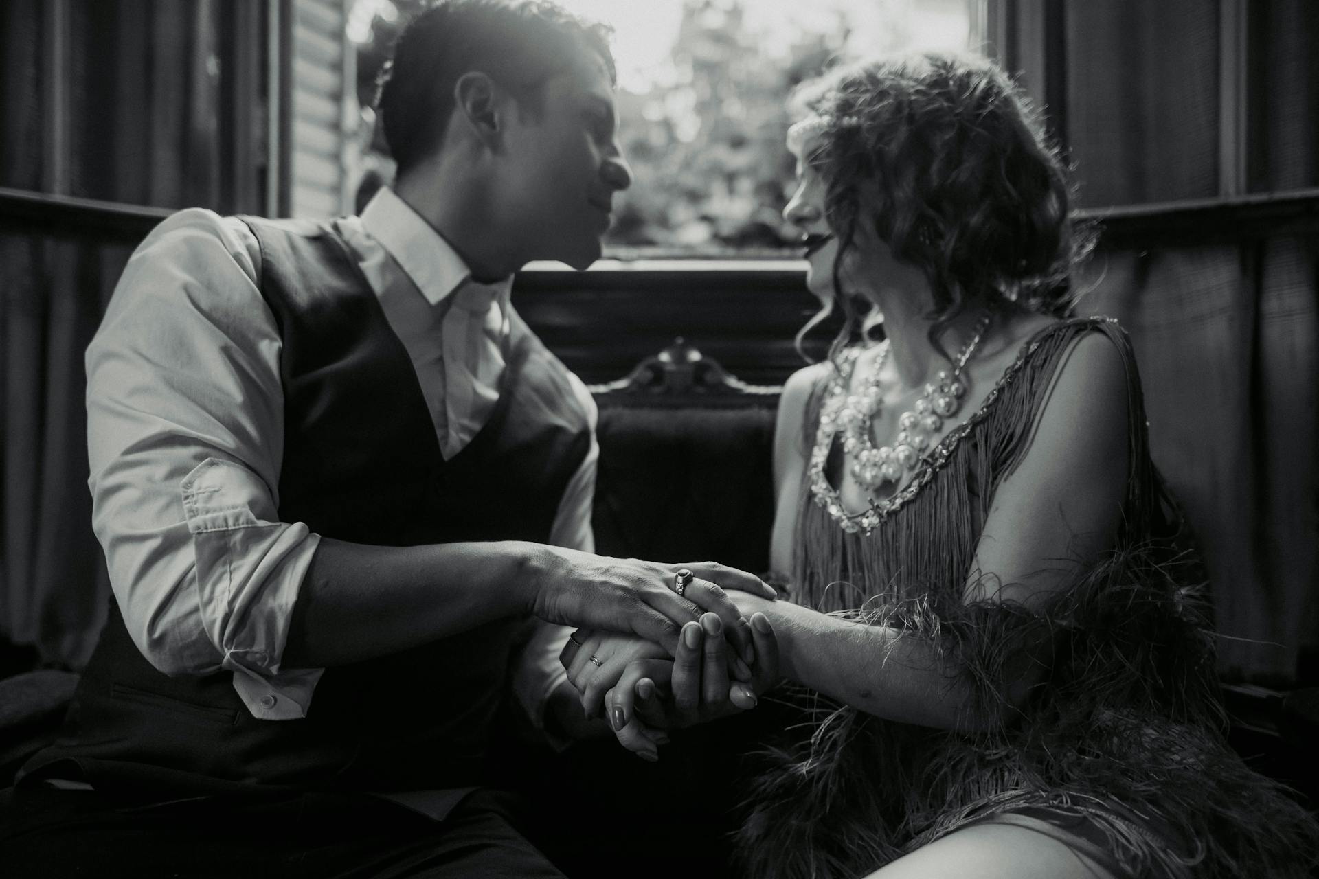 Grayscale shot of a man holding a wealthy woman's hands and looking at her | Source: Pexels