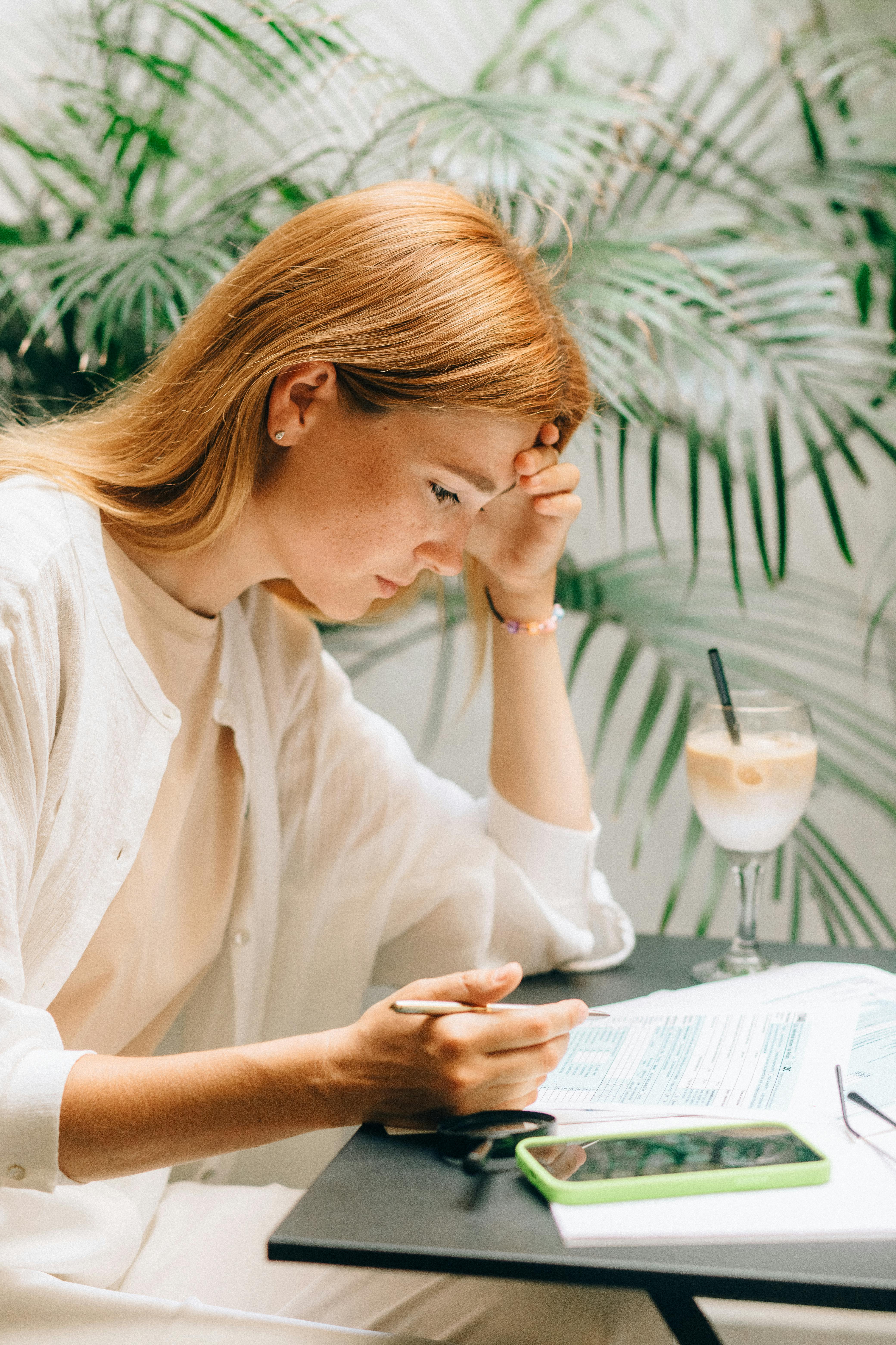 An upset woman looking at paperwork | Source: Pexels