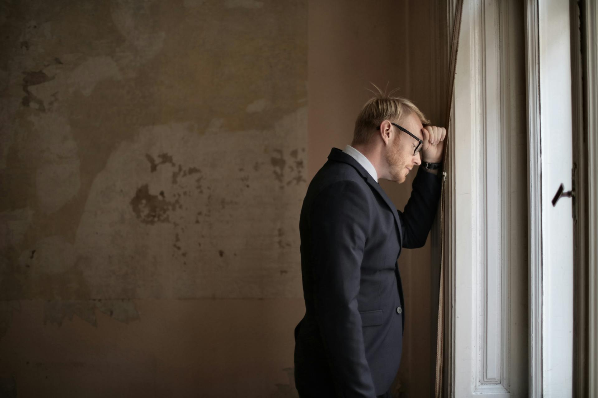 An emotional man leaning against a wall | Source: Pexels