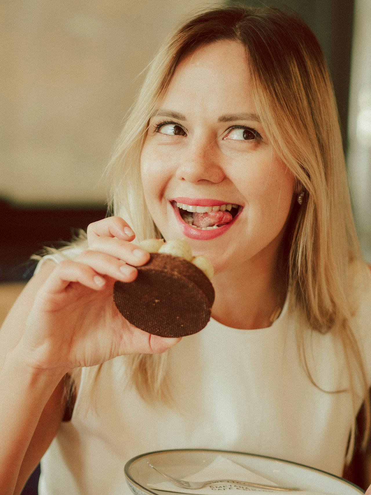 A happy woman eating a cupcake | Source: Pexels