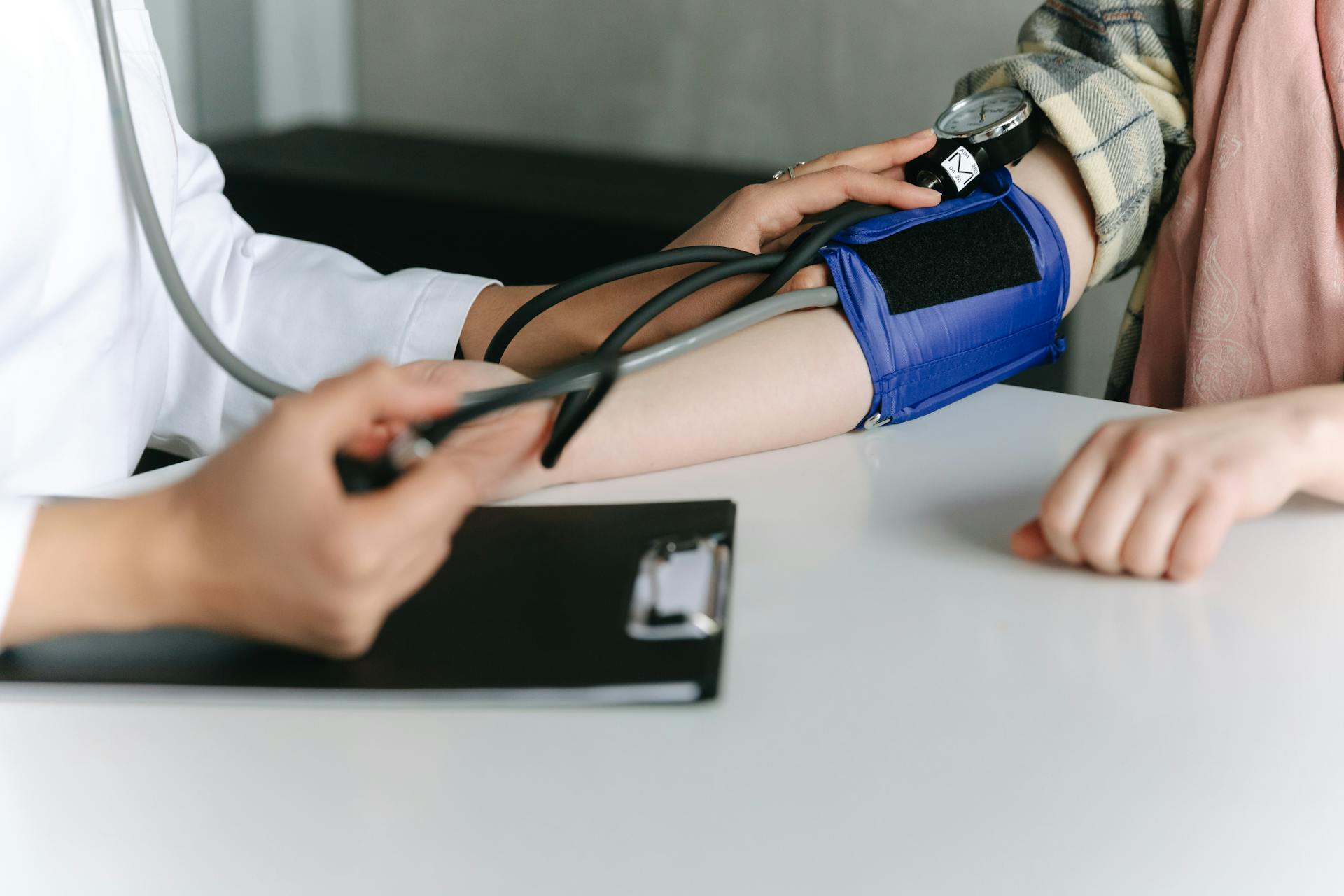 A person measuring measuring a patient's blood pressure | Source: Pexels