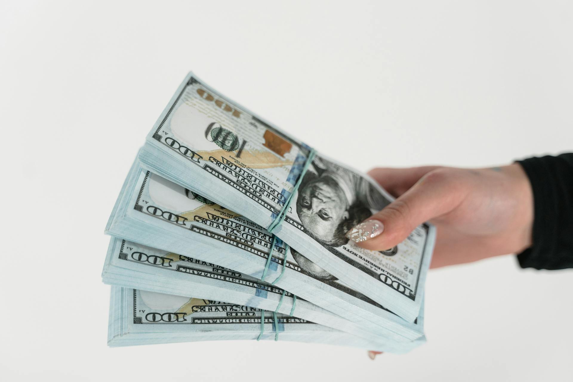 A woman holding wads of money | Source: Pexels