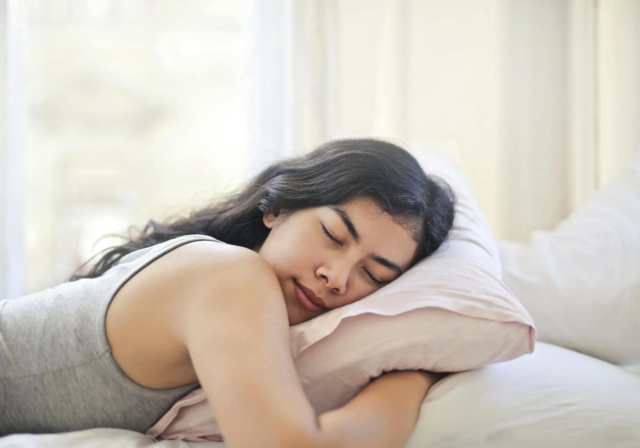 A smiling woman sleeping | Source: Pexels