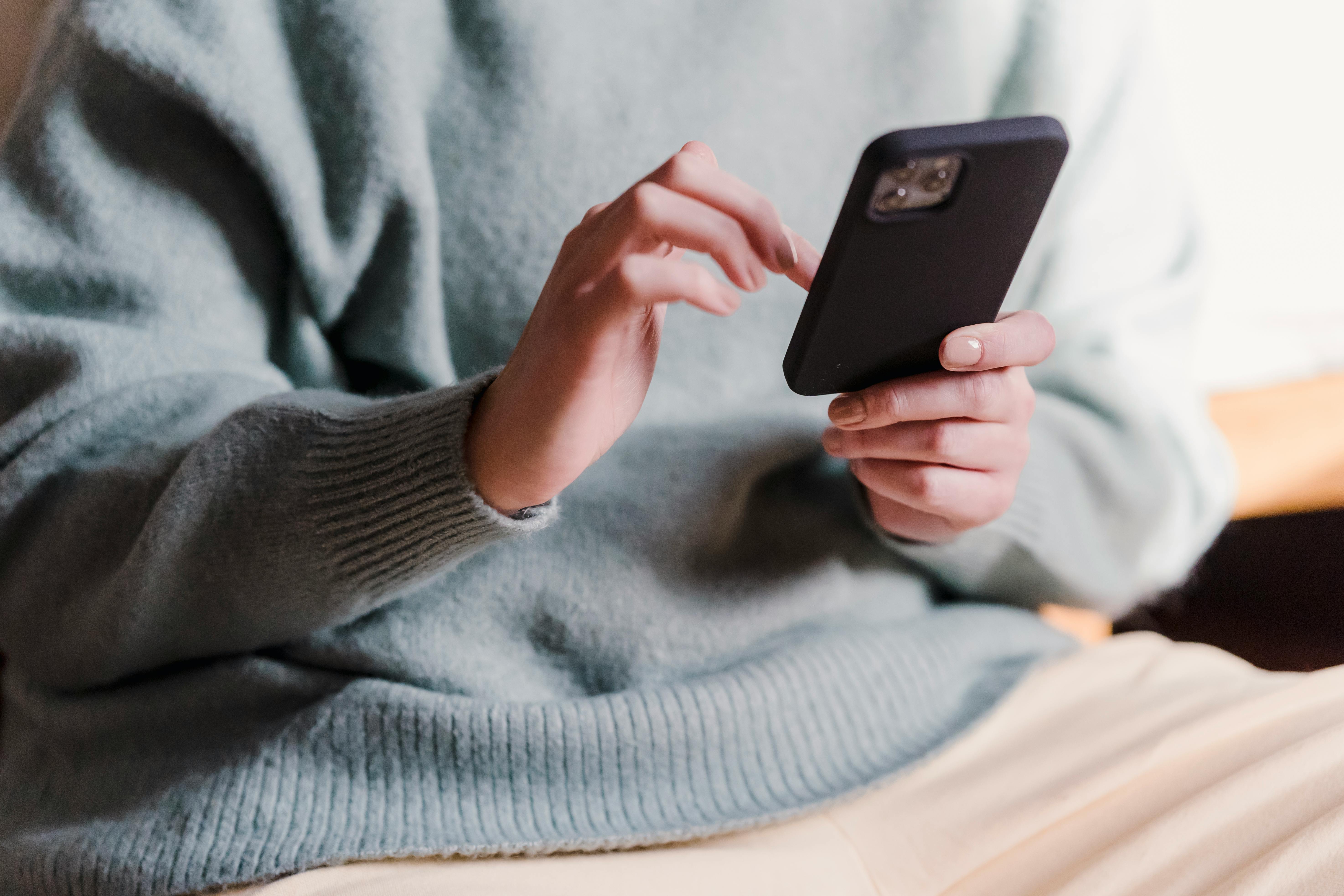 A woman holding a cellphone | Source: Pexels