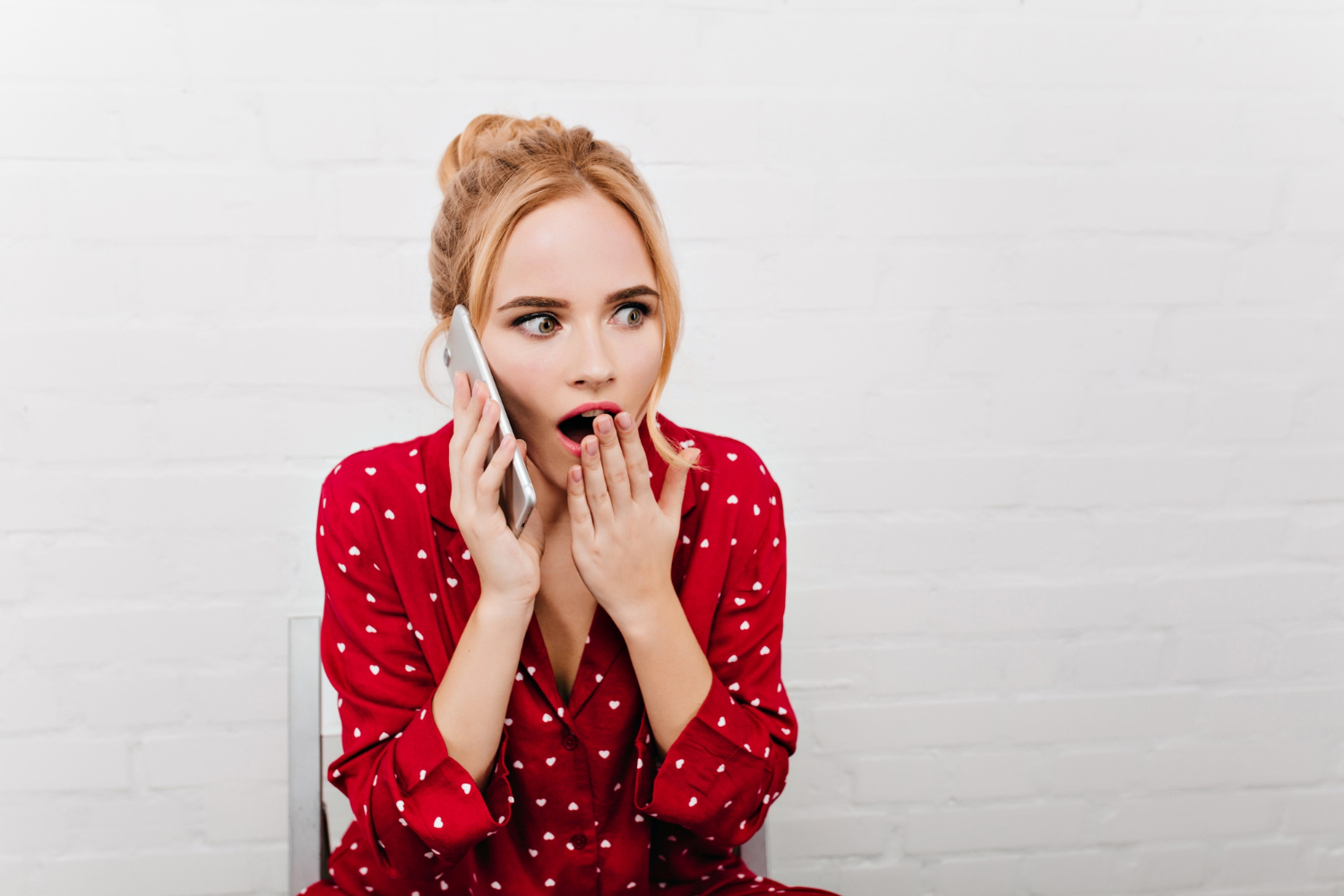 A startled woman talking on the phone | Source: Freepik
