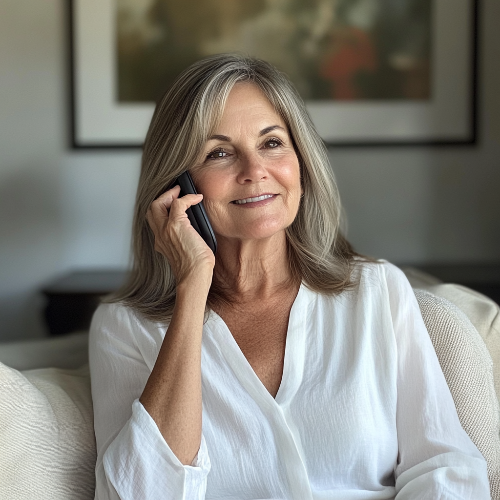A smiling woman talking on a phone | Source: no source