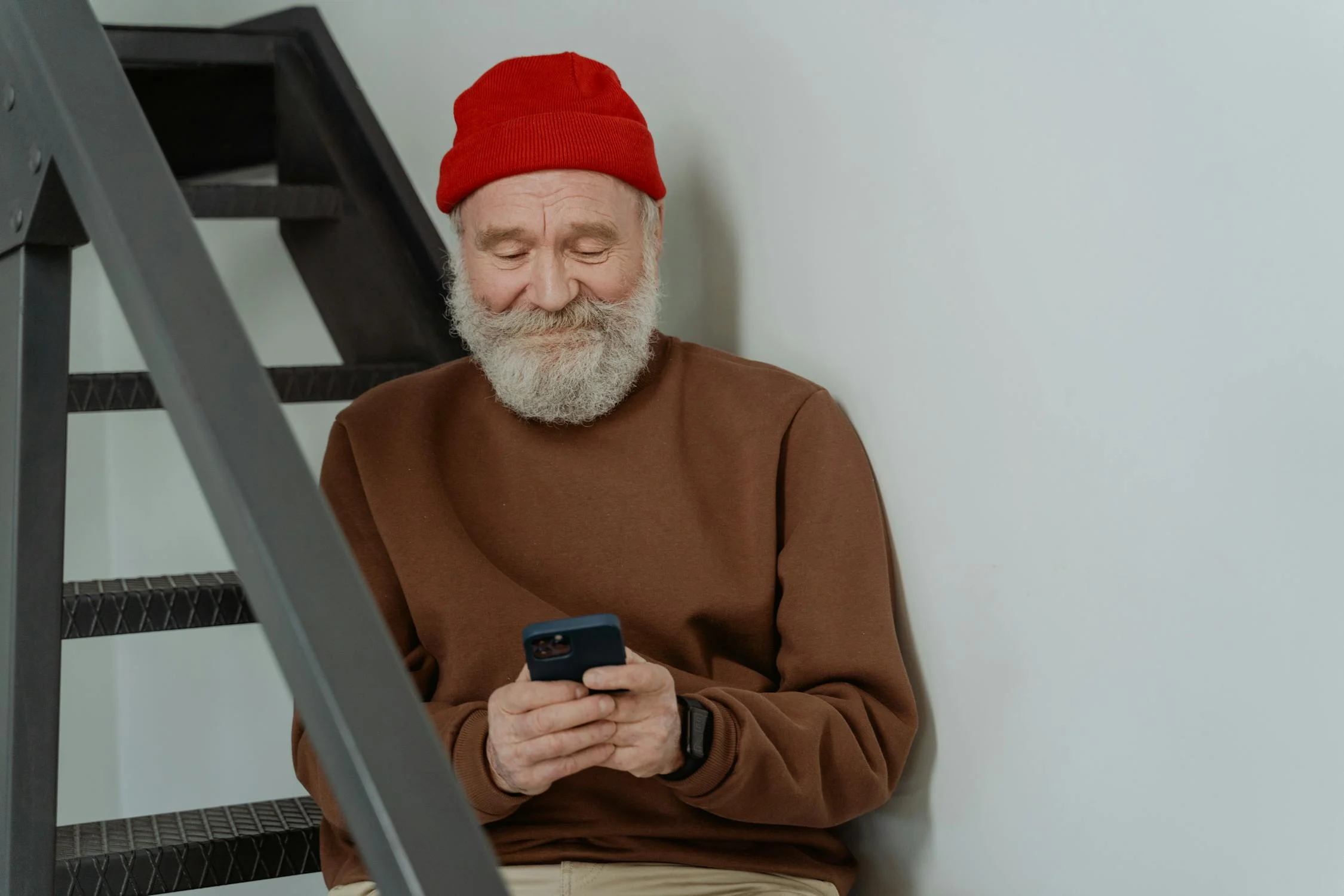 A smiling mature man looking at his phone | Source: Pexels