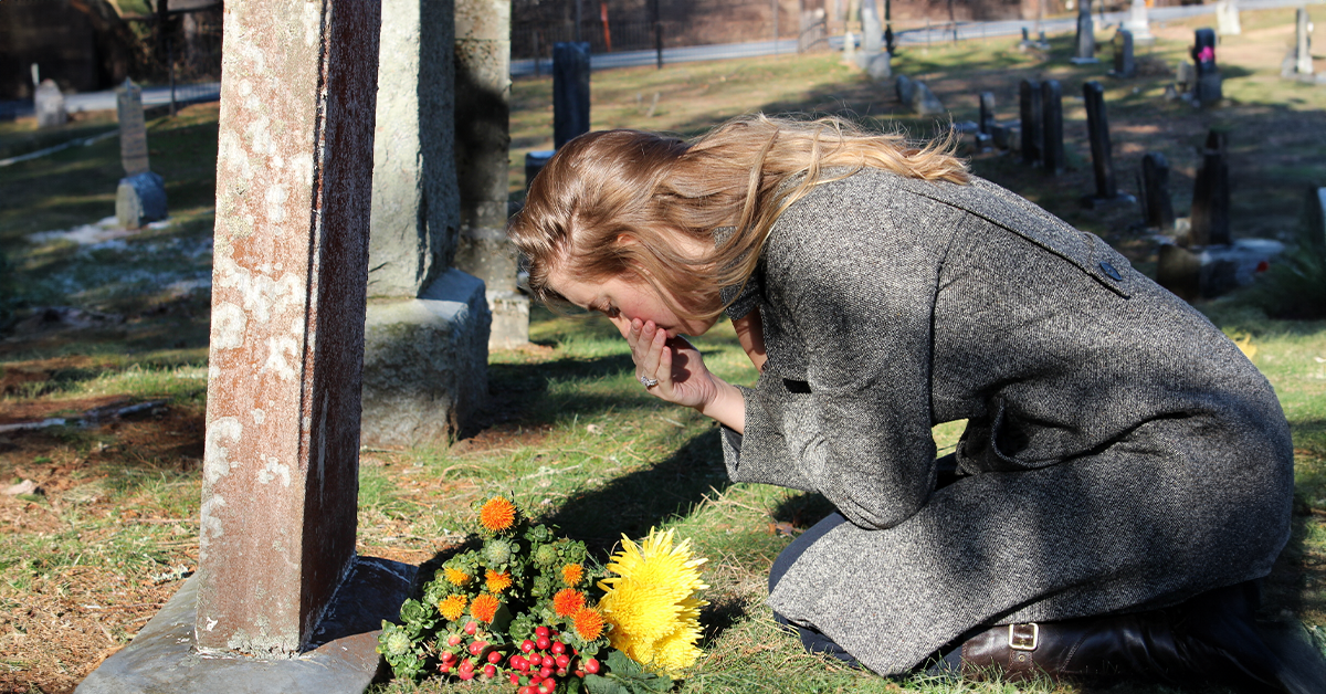 Woman grieving at the grave | Source: Shutterstock