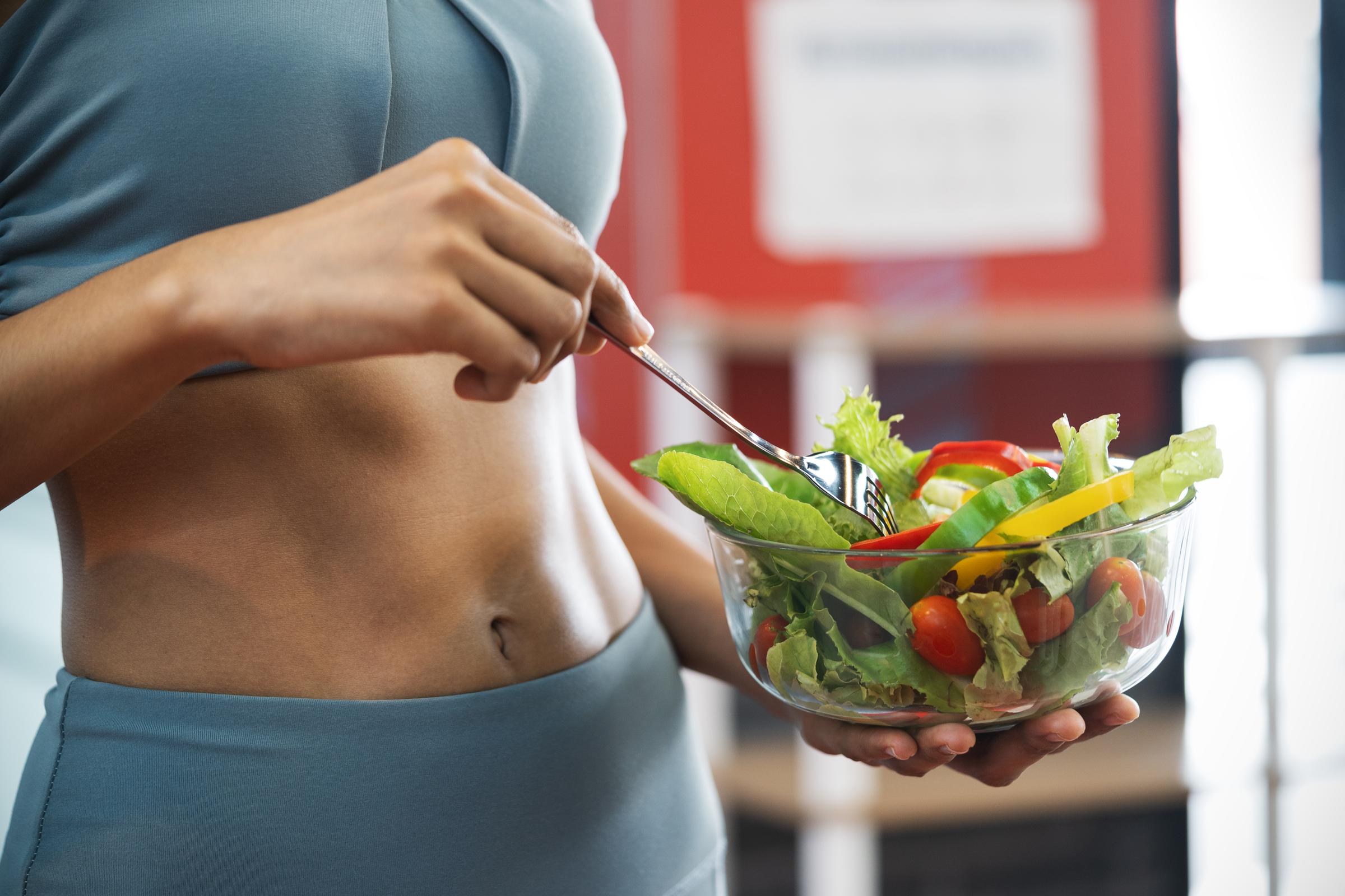 A woman holding a bowl of salad | Source: Getty Images
