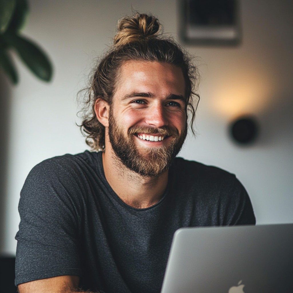 A man with a laptop, smiling  | Source: No source