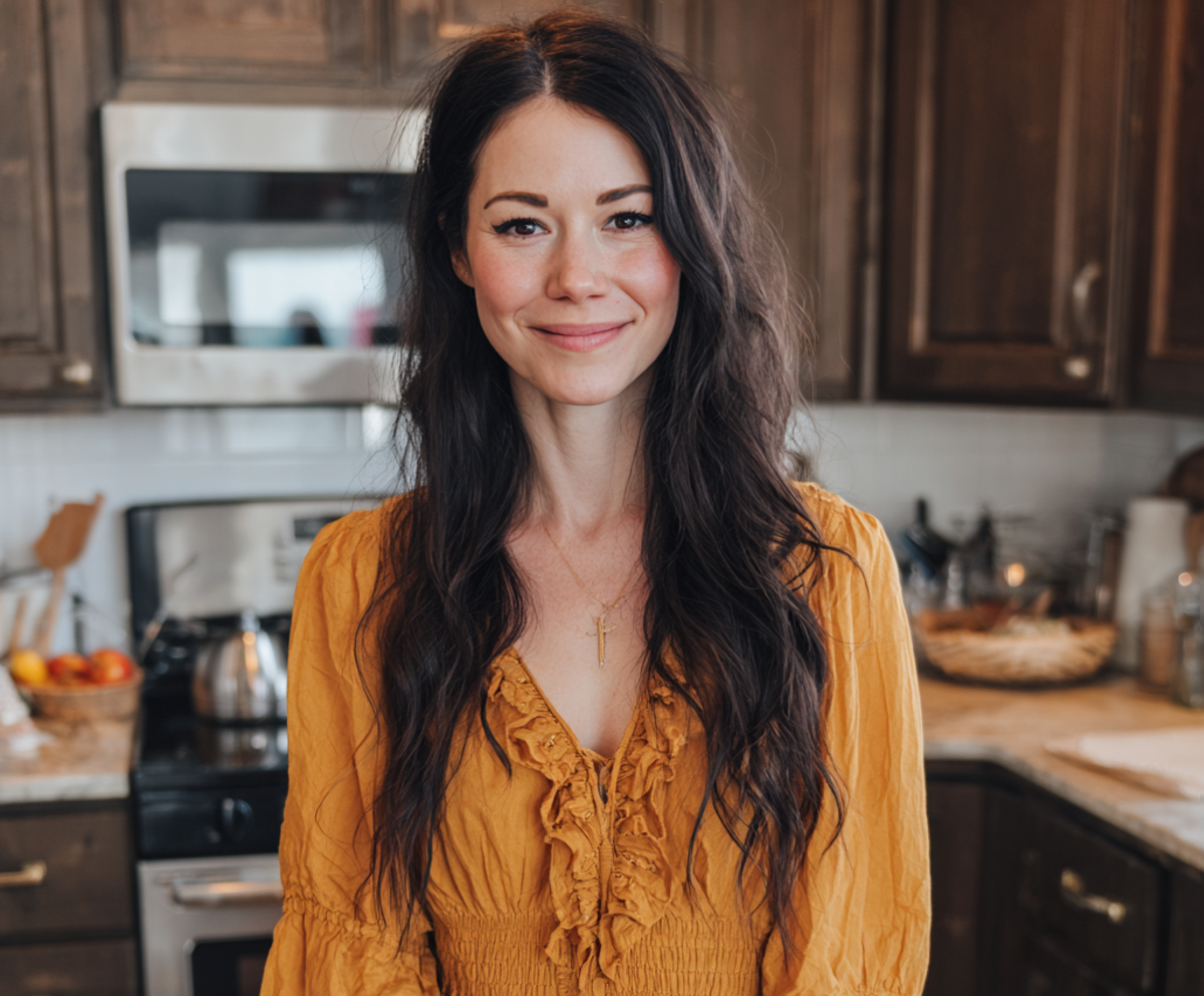 A smiling woman standing in a kitchen | Source: no source
