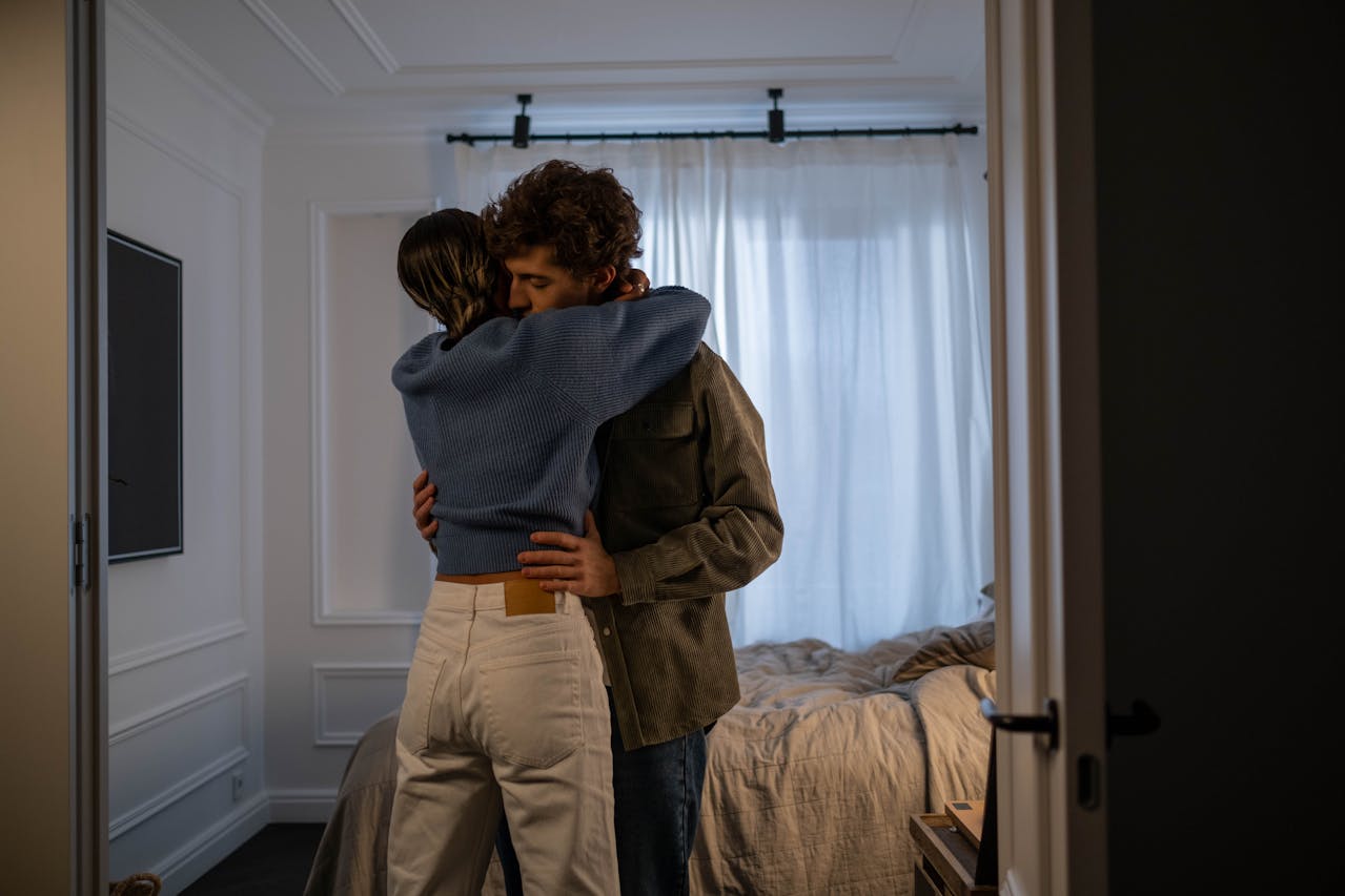 A woman hugging a man in a room | Source: Pexels