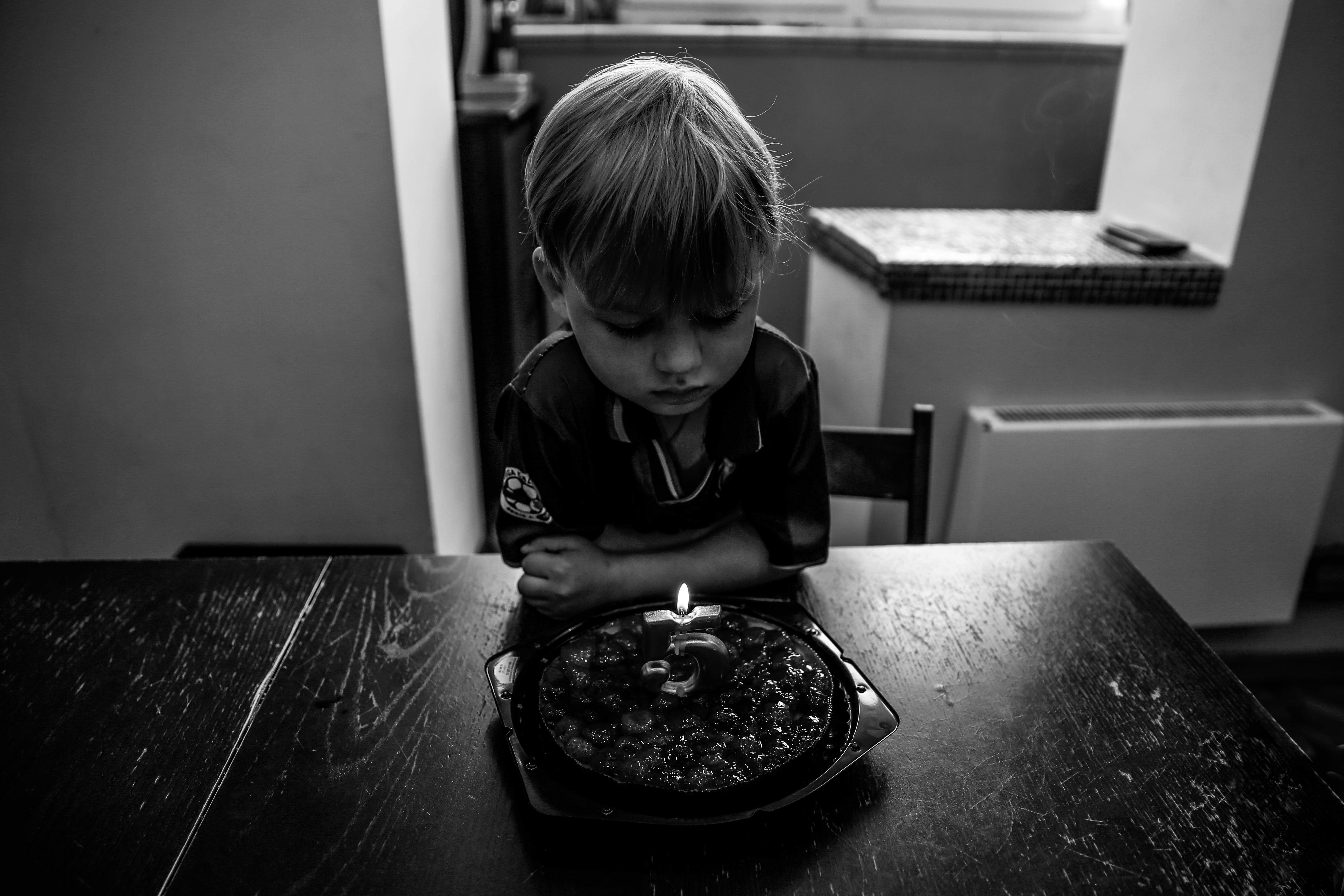 Kid watching a burning candle on a birthday cake | Source: Pexels