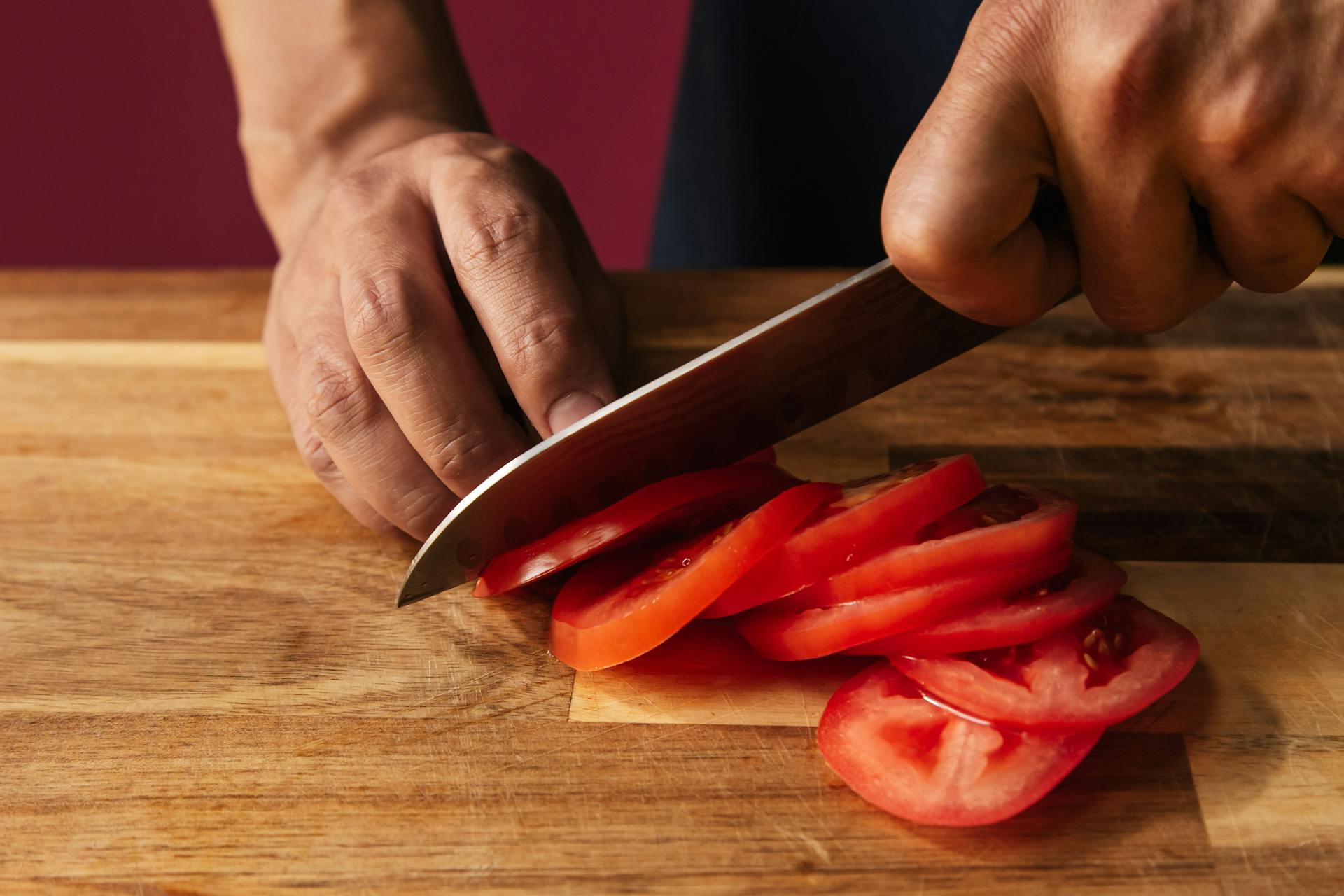 A man slicing tomatoes | Source: Pexels