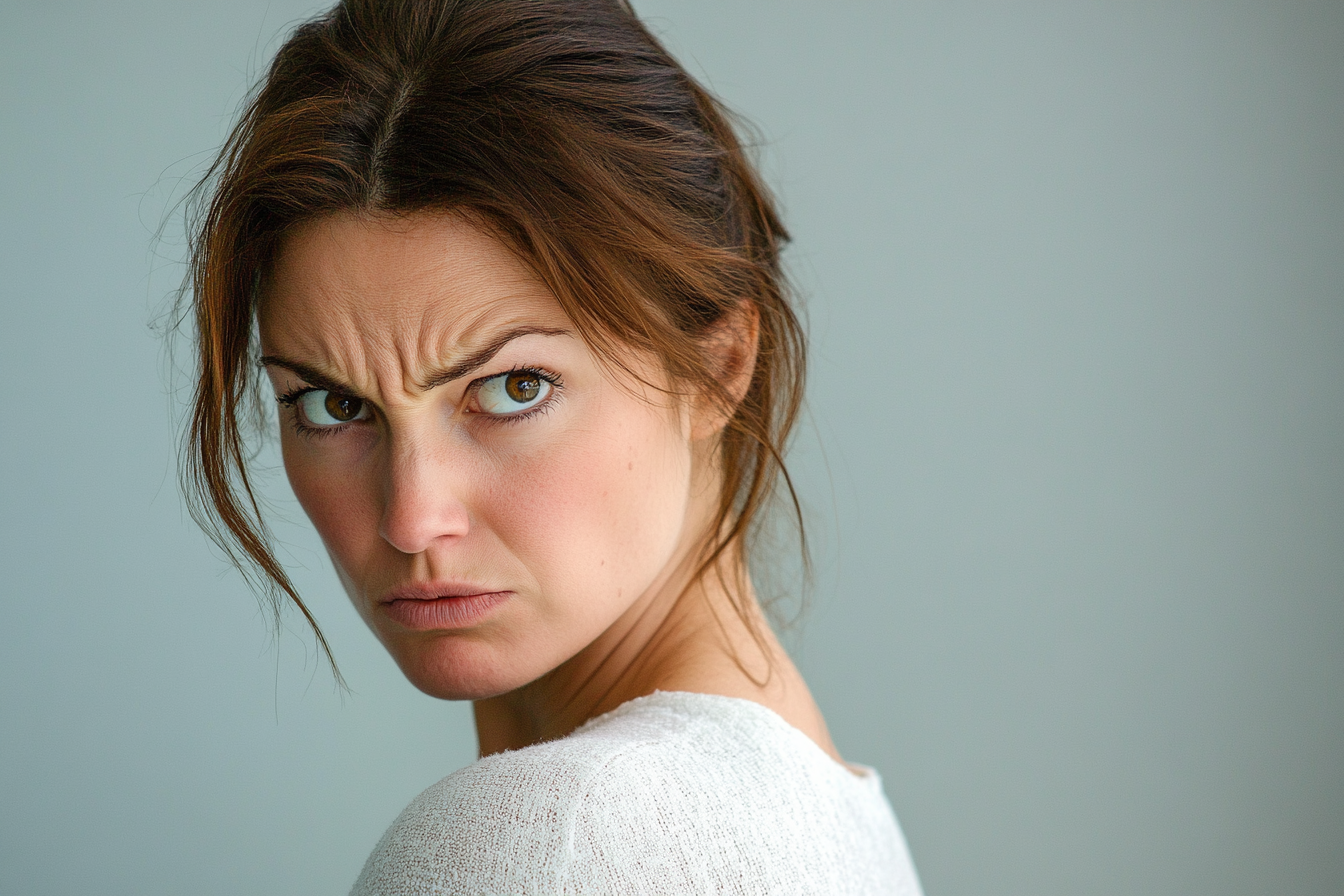 A frowning woman looking over her shoulder | Source: No source
