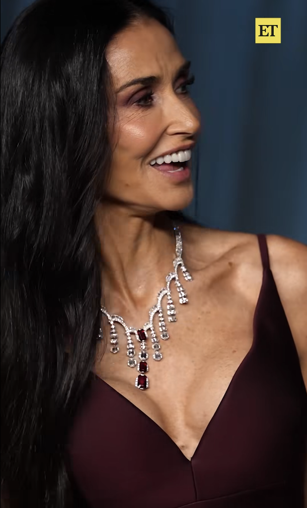 Caught mid-laugh, Demi Moore turns to her left in a candid moment, her expression full of warmth as light reflects off her statement necklace and the rich tones of her maroon gown. | Source: Facebook/EntertainmentTonight