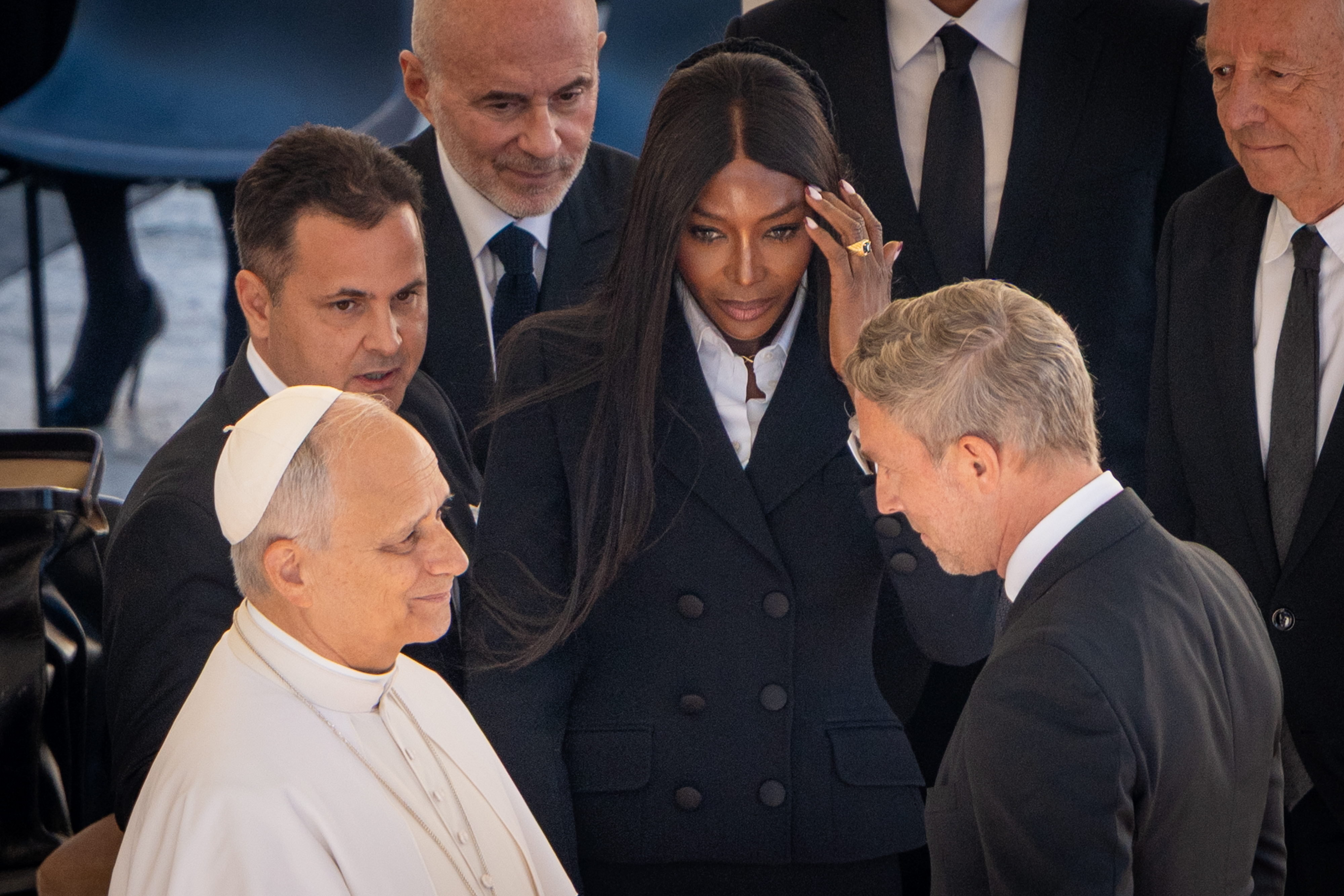 Naomi Campbell looks on as Pope Leo XIV engages with a man in a suit. | Source: Getty Images