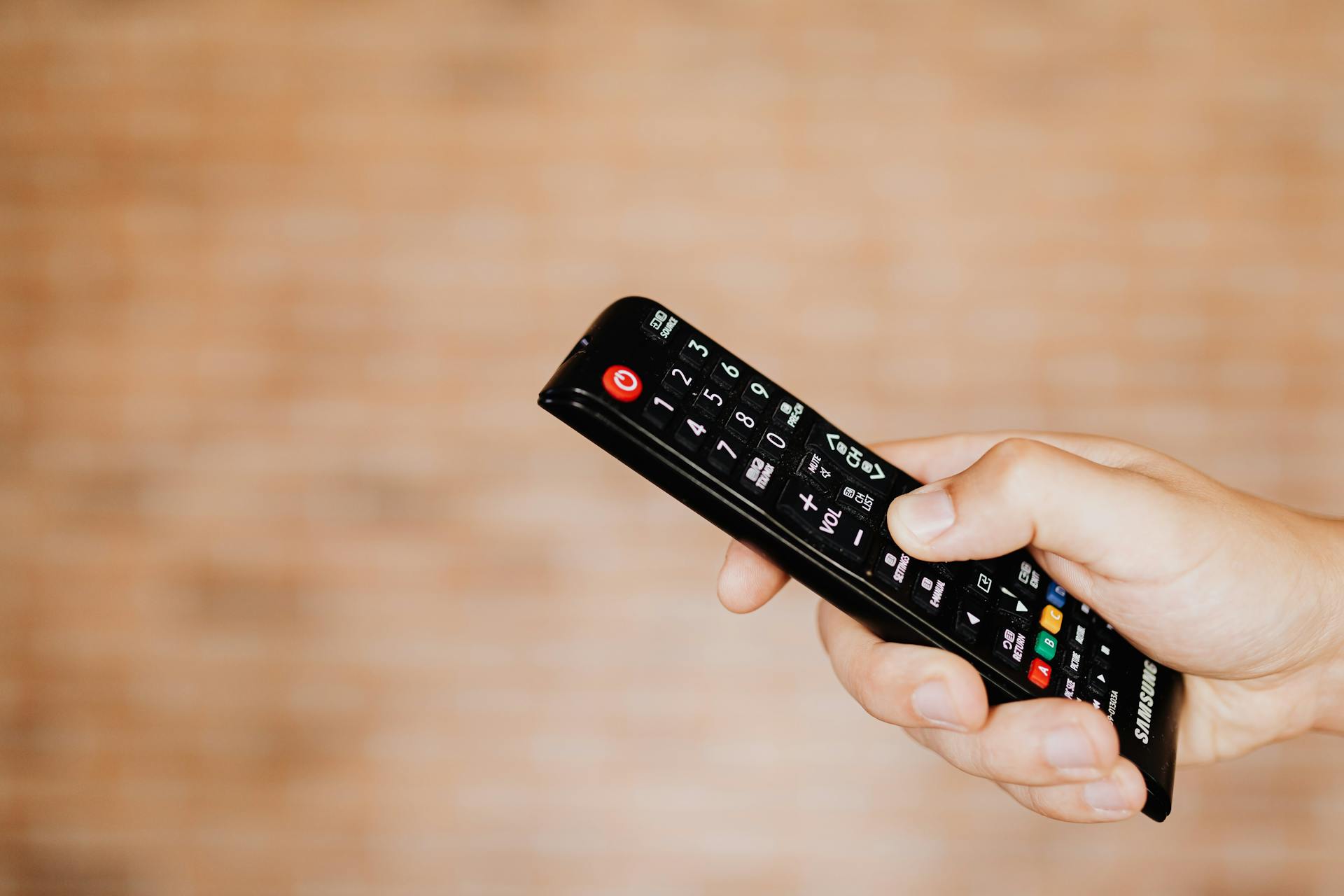 A person holding a TV remote | Source: Pexels