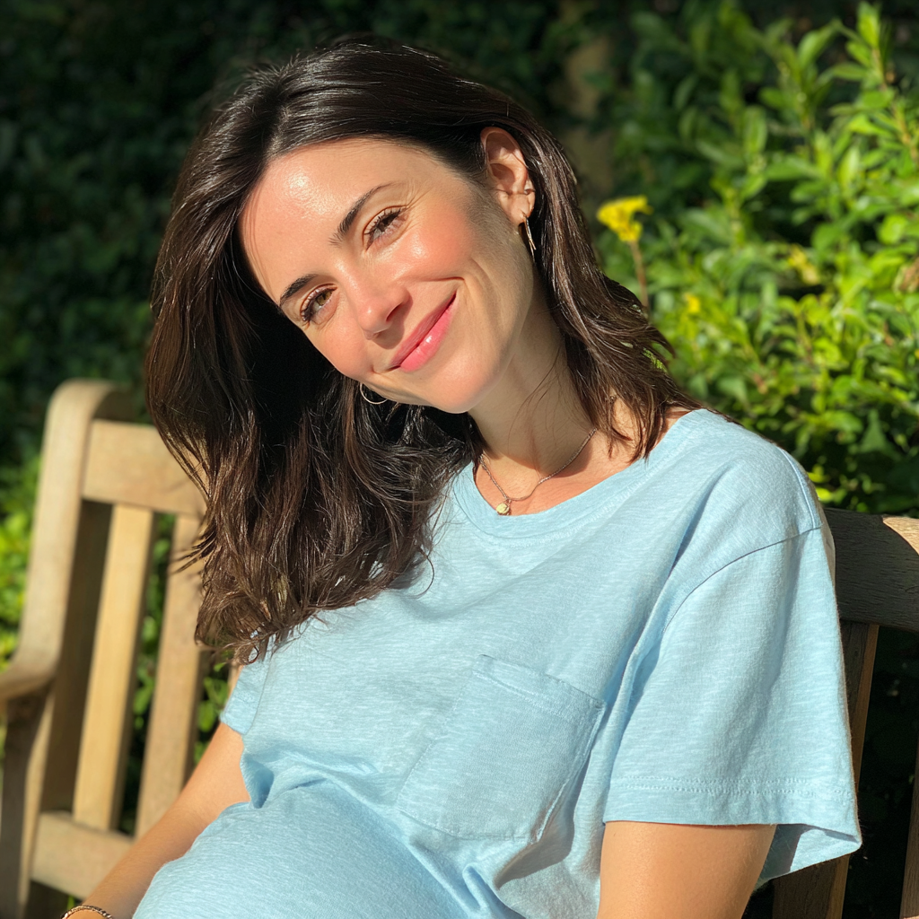 A smiling pregnant woman sitting outside | Source: No source