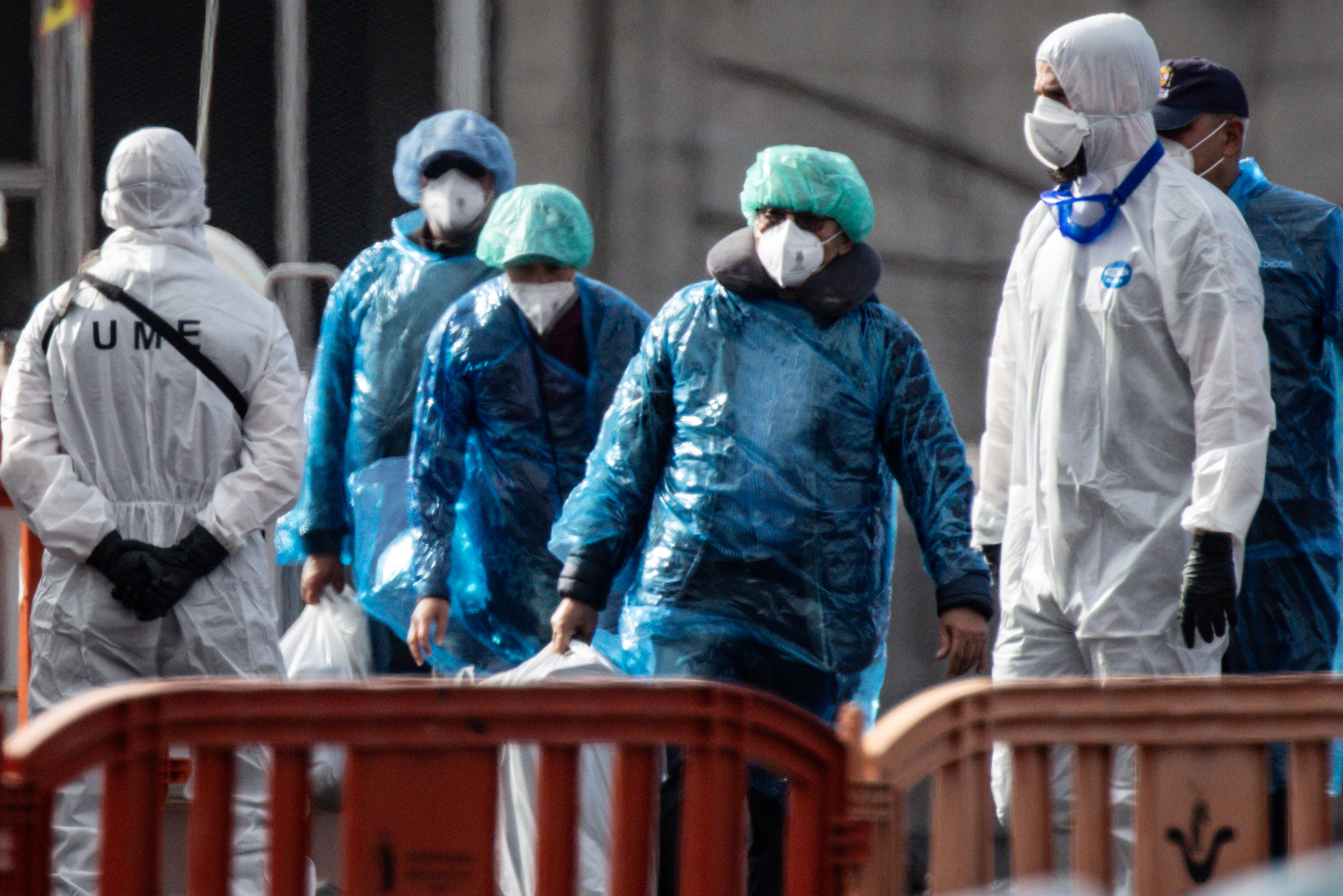 Passengers carry their belongings in plastic bags after being evacuated from the MV Hondius after docking in the Granadilla Port on May 10, 2026 in Tenerife, part of the Canary Islands, Spain. | Source: Getty Images