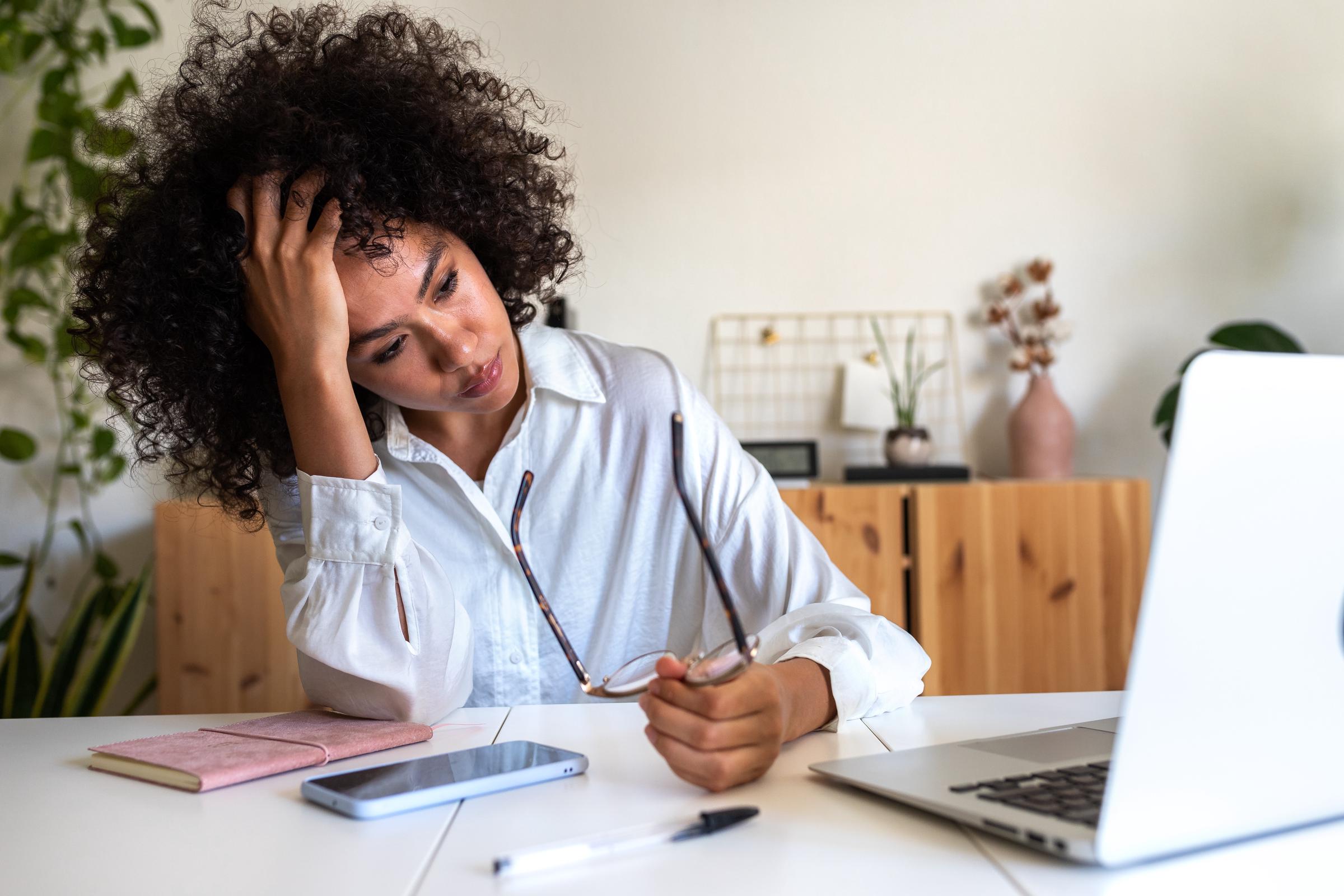 A tired woman looking at laptop in her office | Source: Getty Images