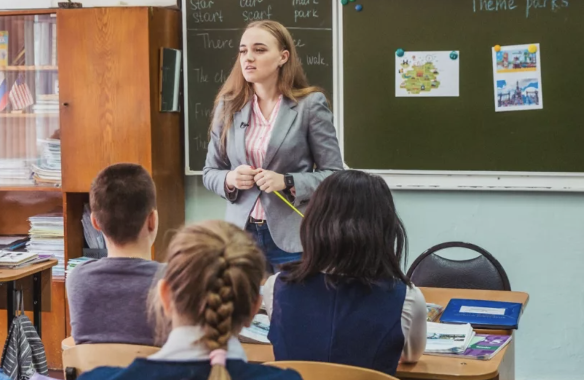 Young teacher in front of class | Source: Shutterstock.com