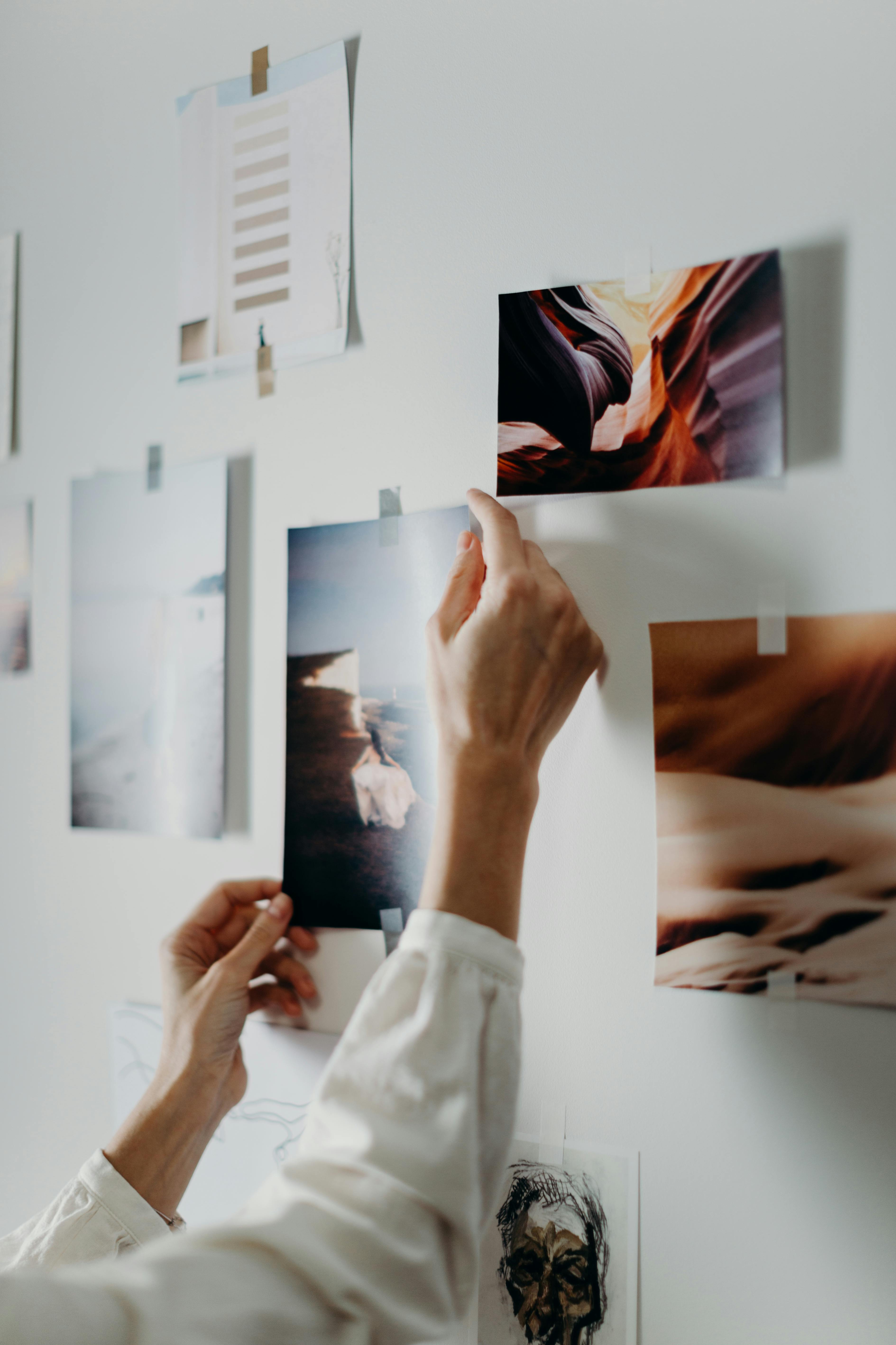 A person putting photos on a wall | Source: Pexels