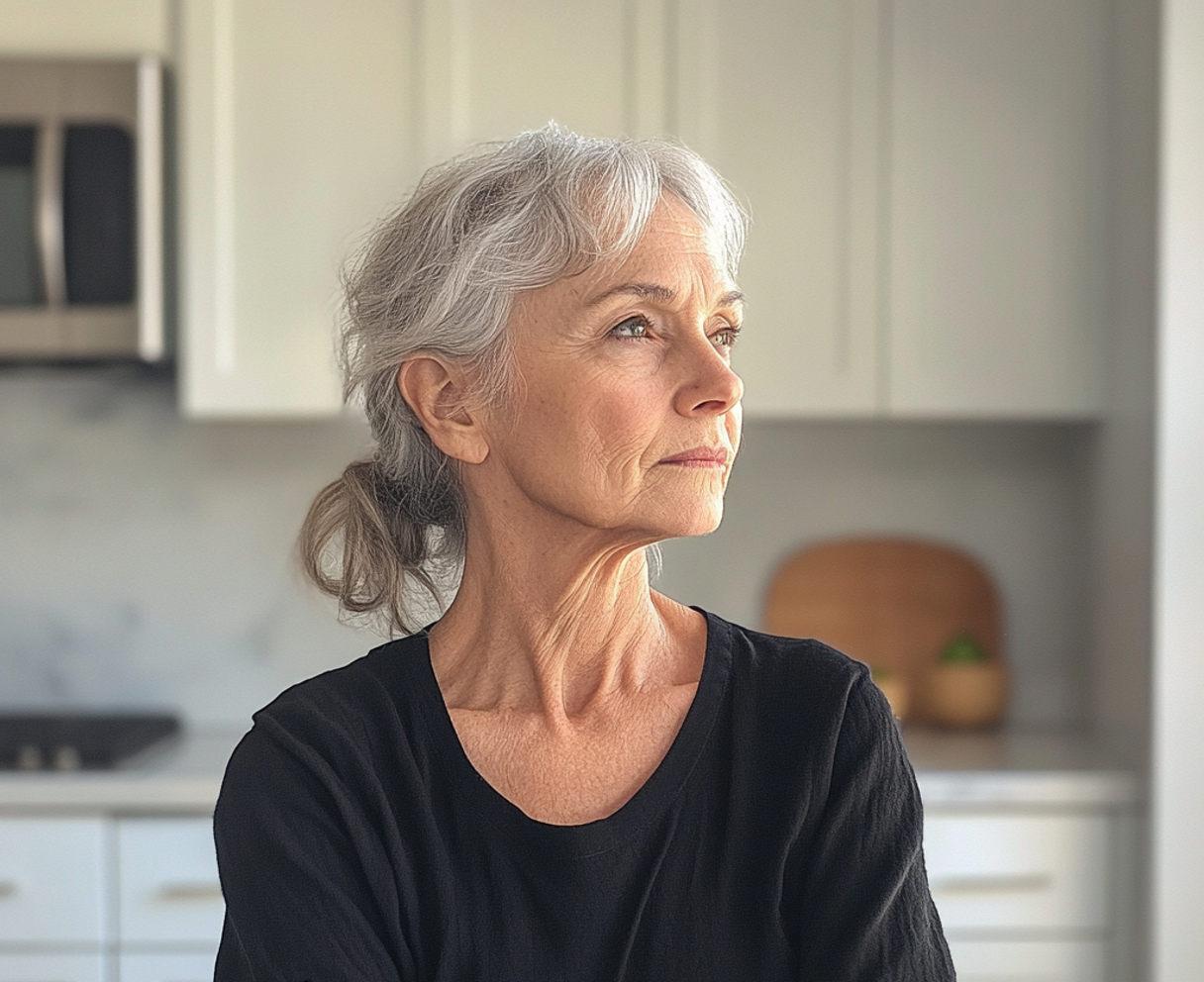 An older woman standing in a kitchen | Source: no source