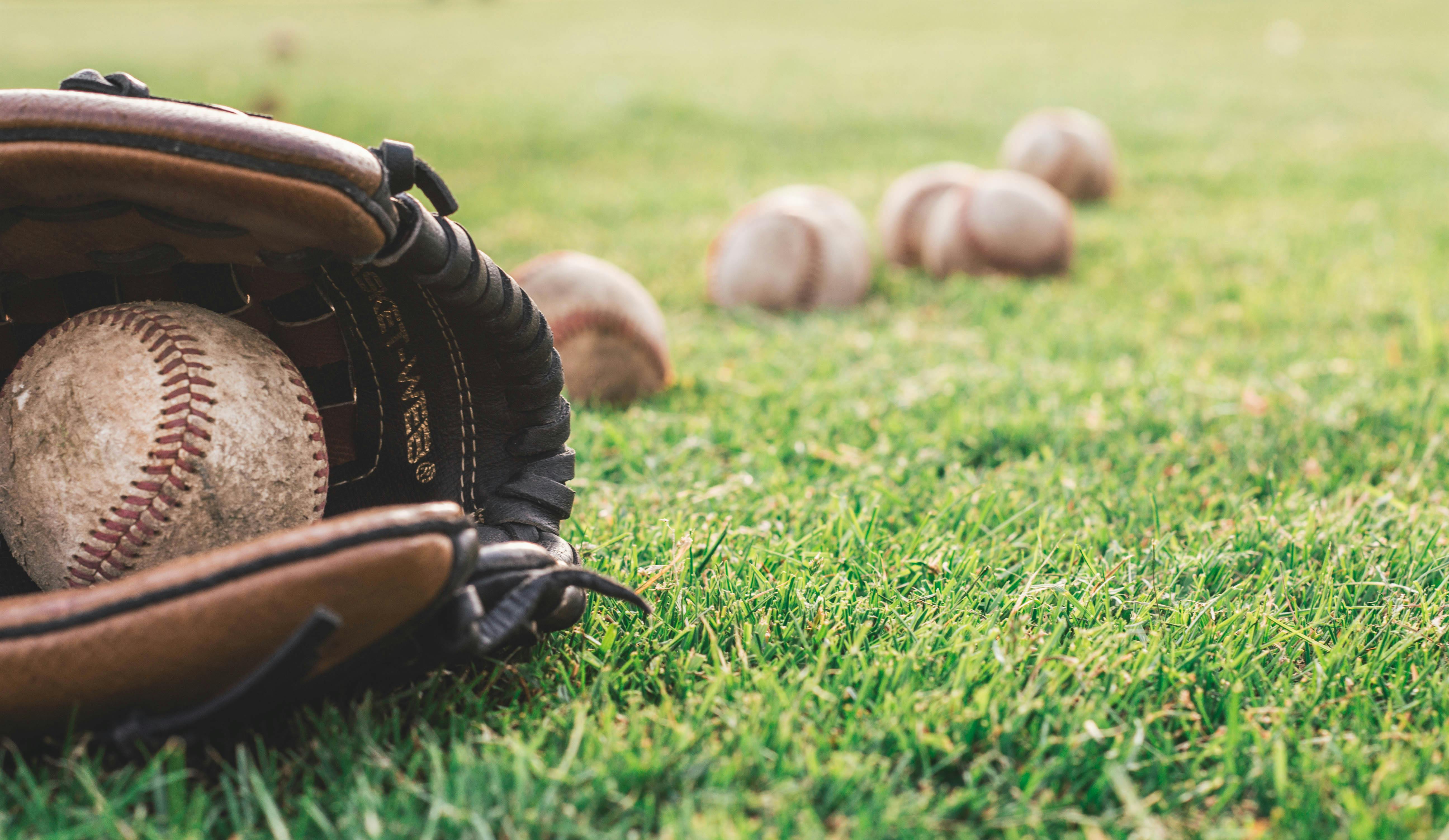 A white baseball on a brown leather baseball glove | Source: Pexels