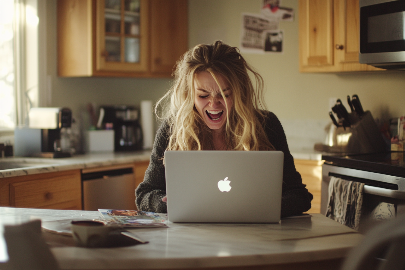 A woman cackling while using her laptop | Source: No source