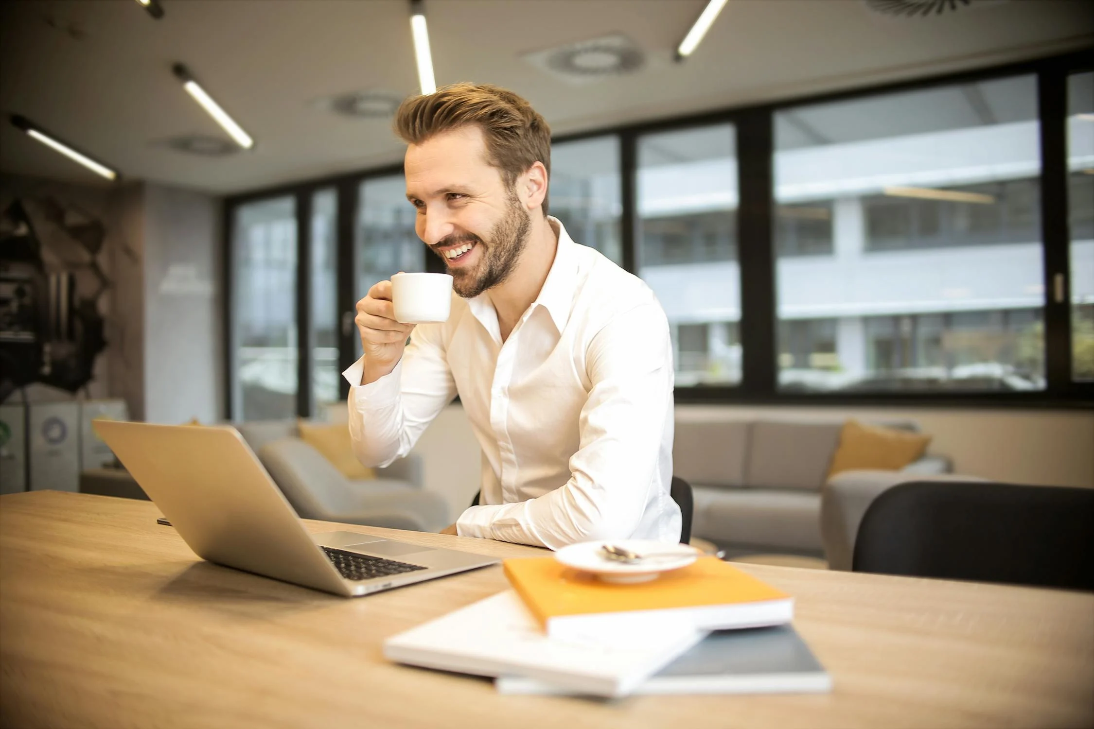 A man drinking coffee while looking at his laptop | Source: Pexels