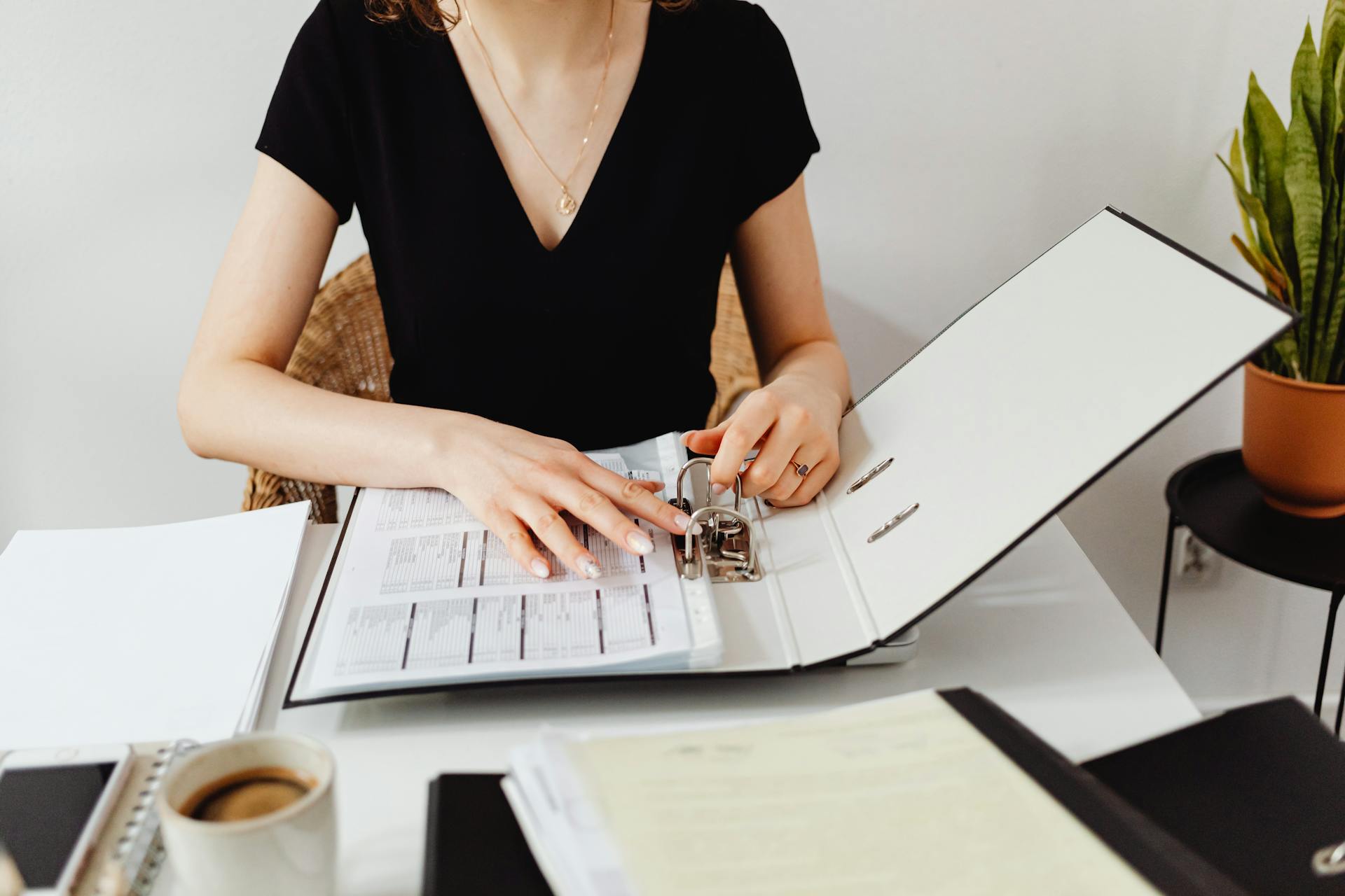 A person going through documents in a binder | Source: Pexels